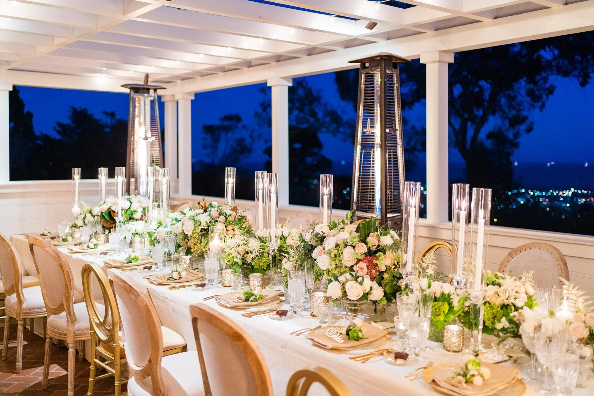 Fireside Patio wedding reception with floral centerpieces, candles, and sunset views of Santa Barbara at Belmond El Encanto