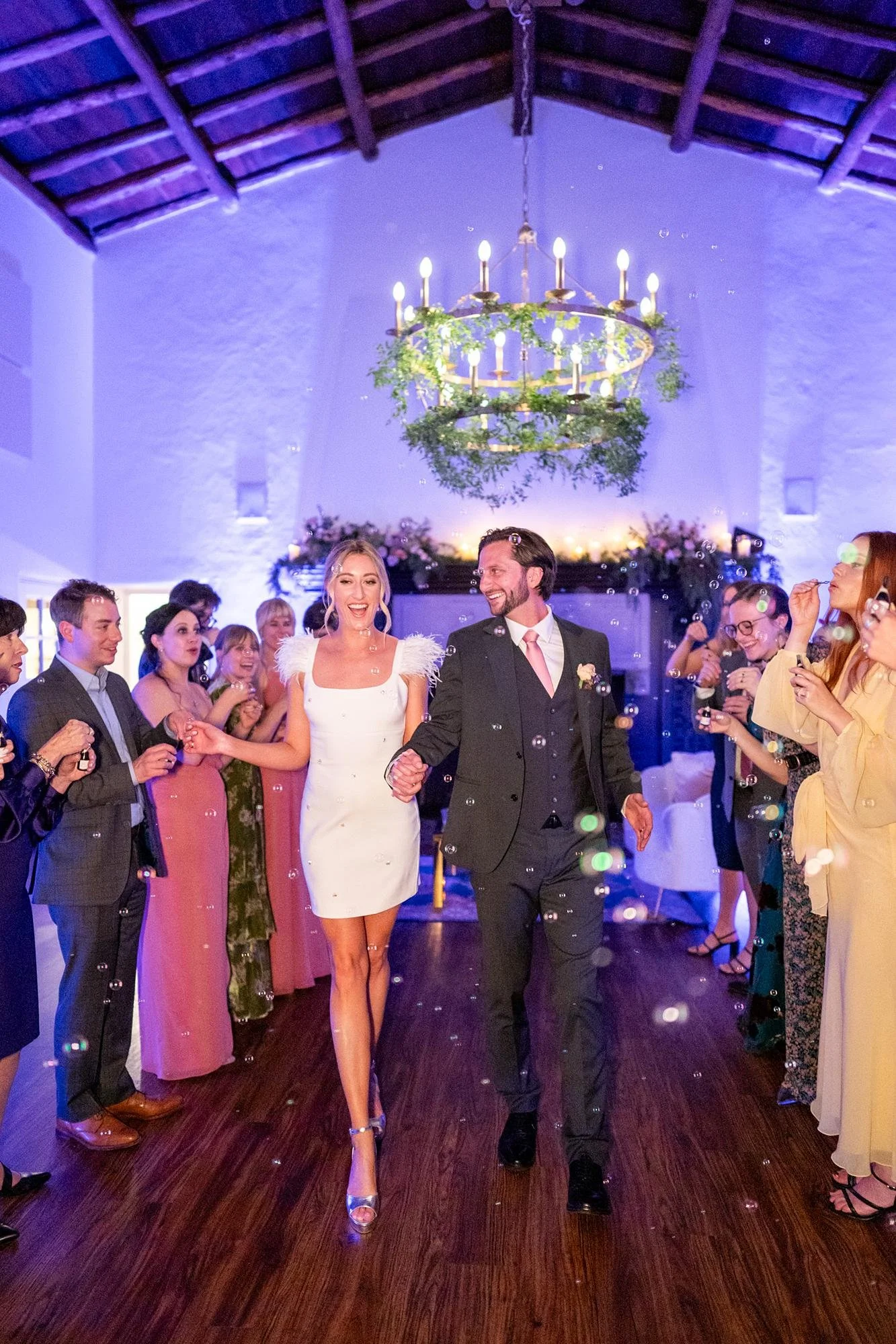 Bride and groom leaving during Ballroom grand exit with guests blowing bubbles at La Venta Inn