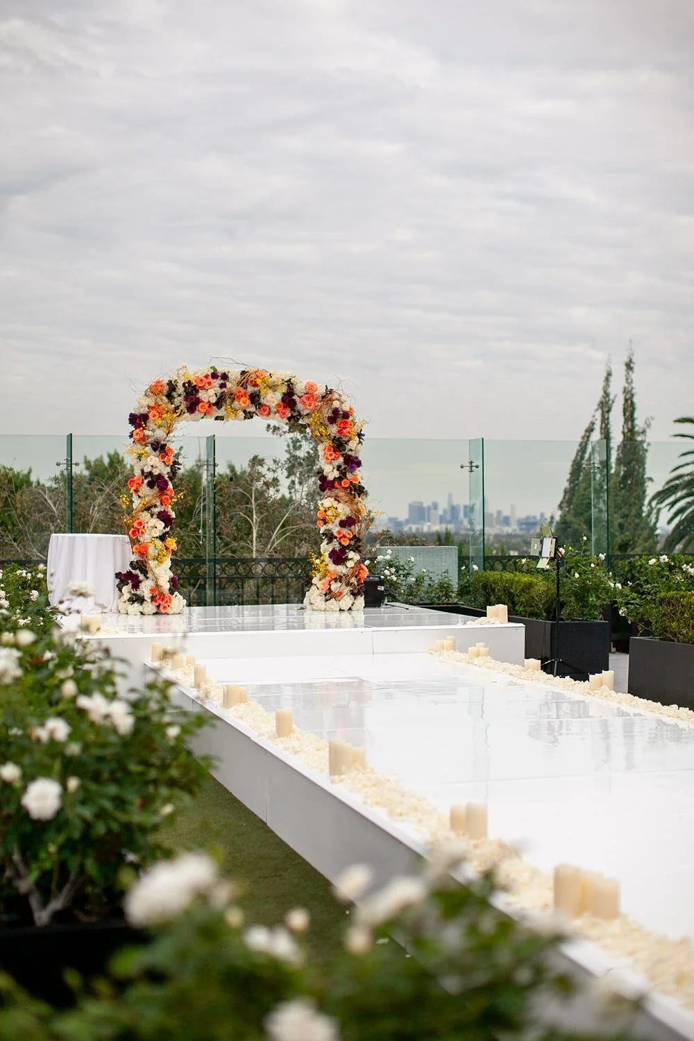 Wedding ceremony at the London West Hollywood in Hampton Court with a vibrant orange floral arch
