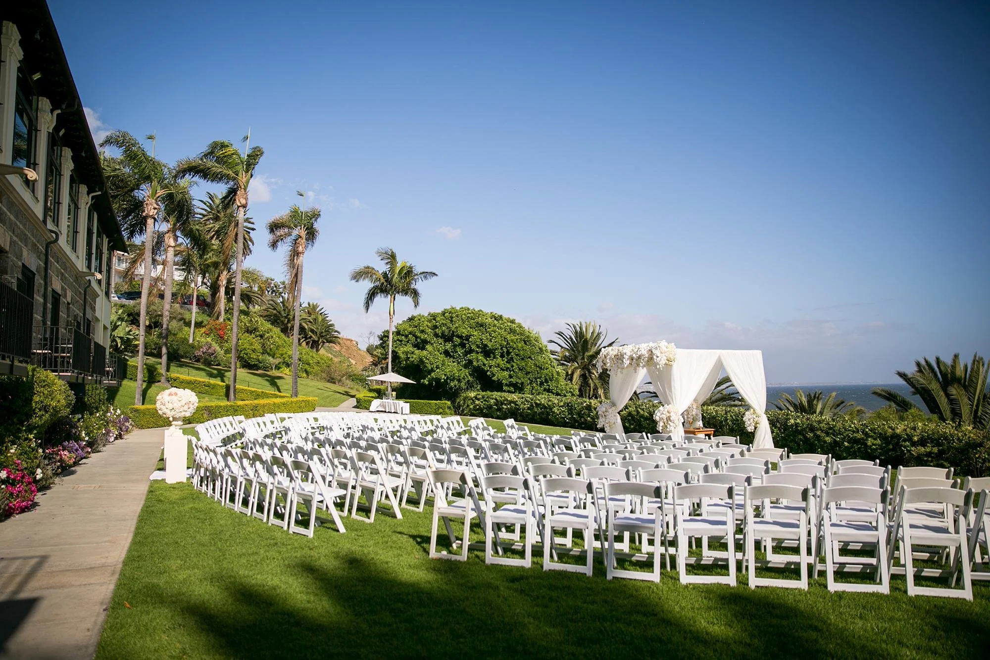 Wide view of an Ocean Lawn wedding ceremony with guests and ocean backdrop at Bel Air Bay Club
