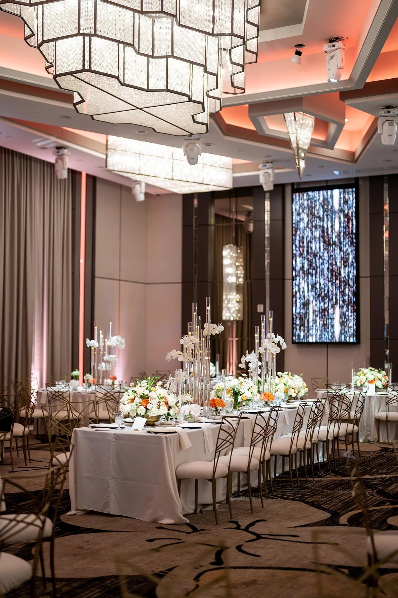 Wedding reception at Landmark Mission Hills with long table under chandelier and florals