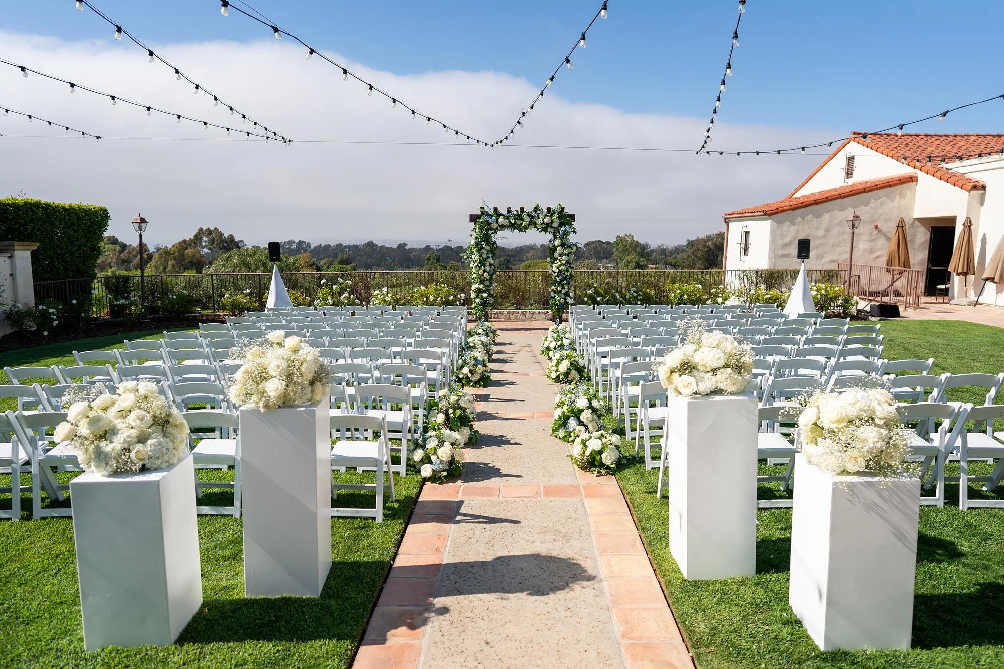 Wedding ceremony aisle lined with roses and pedestal florals at Palos Verdes Golf Club