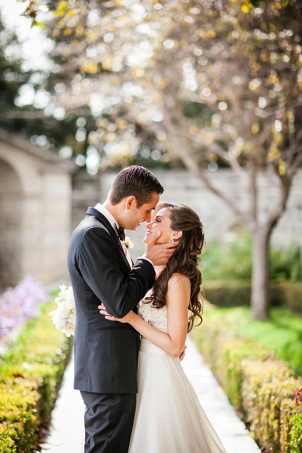 Wedding portrait of bride and groom kissing beside the Reflection Pond at Greystone Mansion