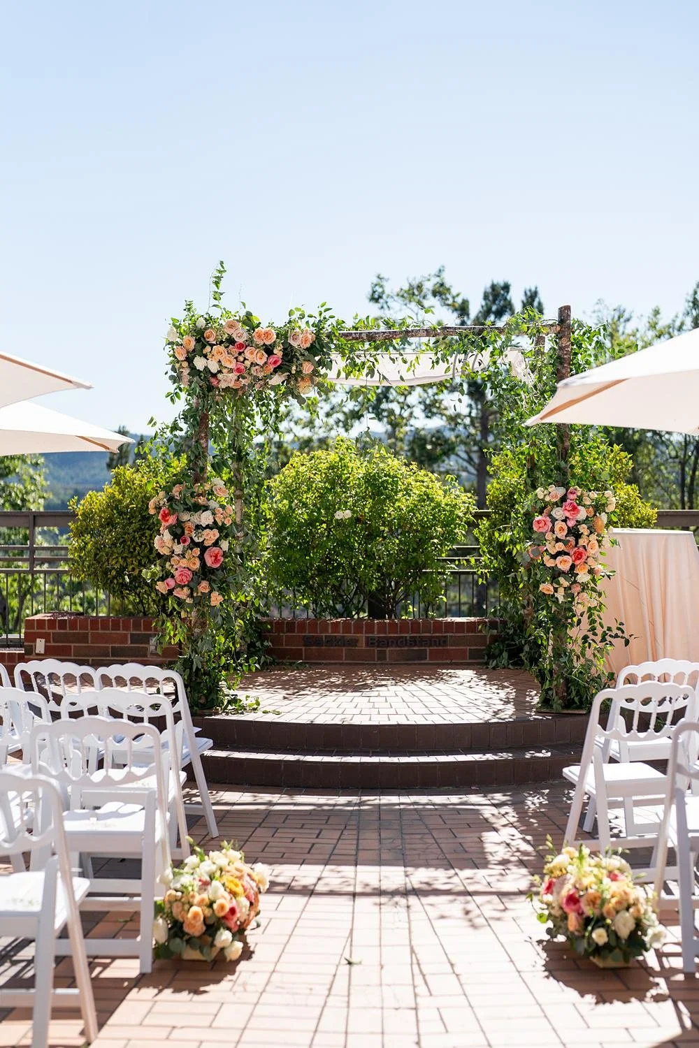 Wedding ceremony detail of chuppah draped with greenery and orange florals at Stephen Wise Temple