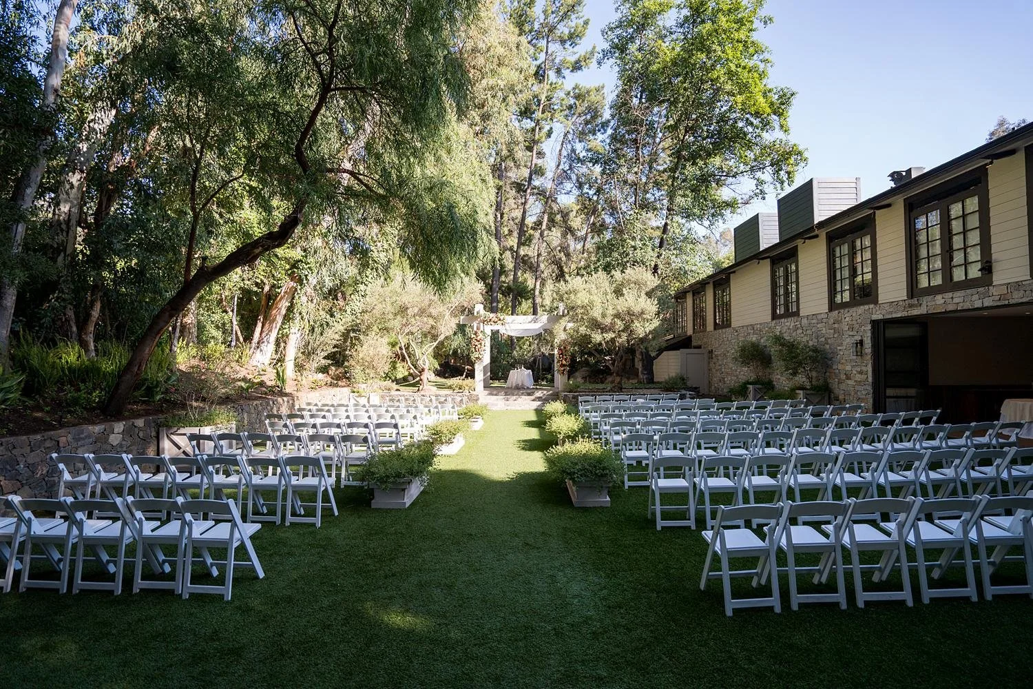 Wedding ceremony at Calamigos Ranch Redwood Room with a chuppah decorated in cascading roses