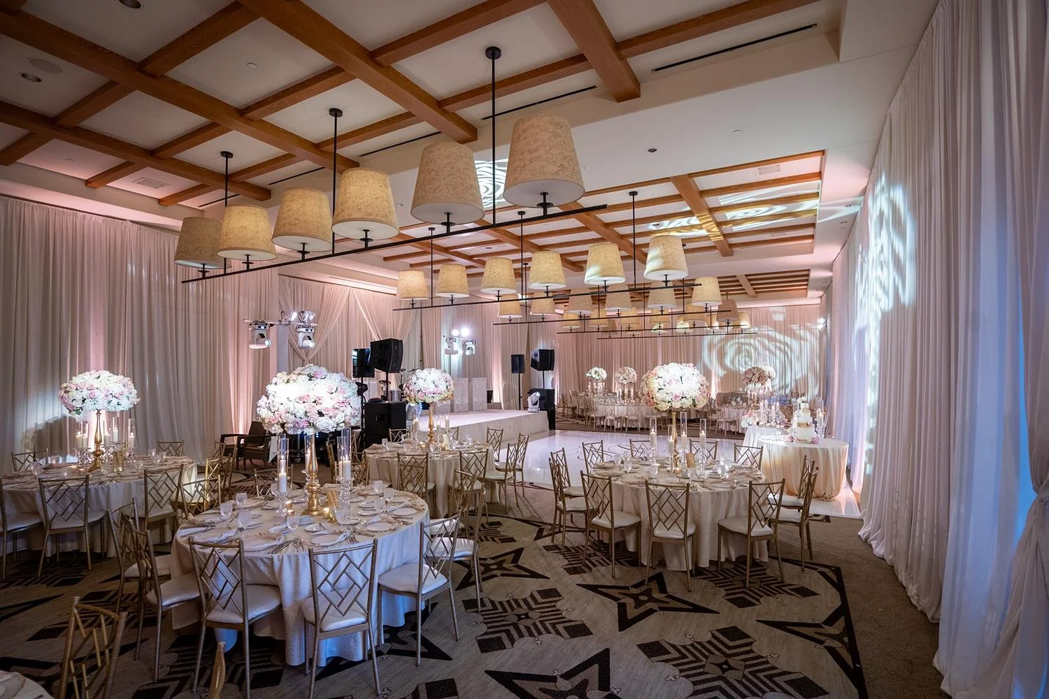 Wide view of Catalina Ballroom wedding reception with pink and white florals and drapery at Terranea Resort