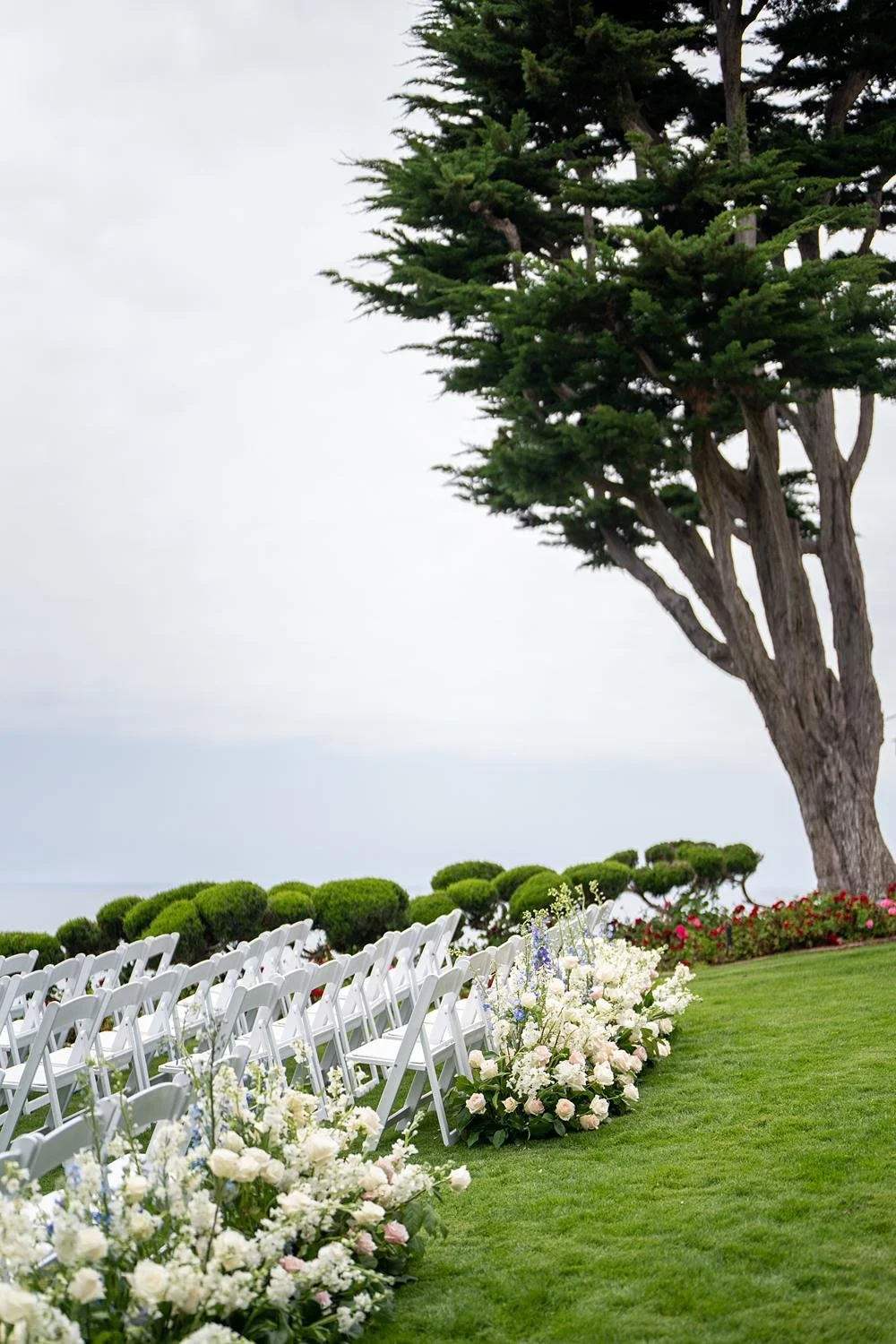 Wedding ceremony aisle lined with roses and greenery at Cypress Sea Cove