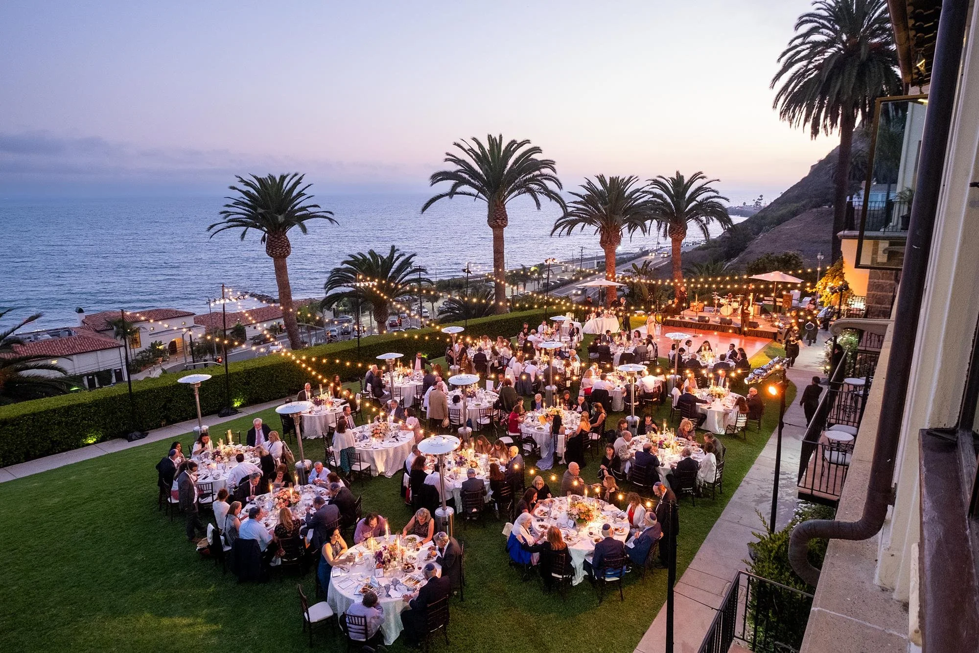 Evening wedding reception on the Ocean Lawn with guests and ocean views at Bel Air Bay Club