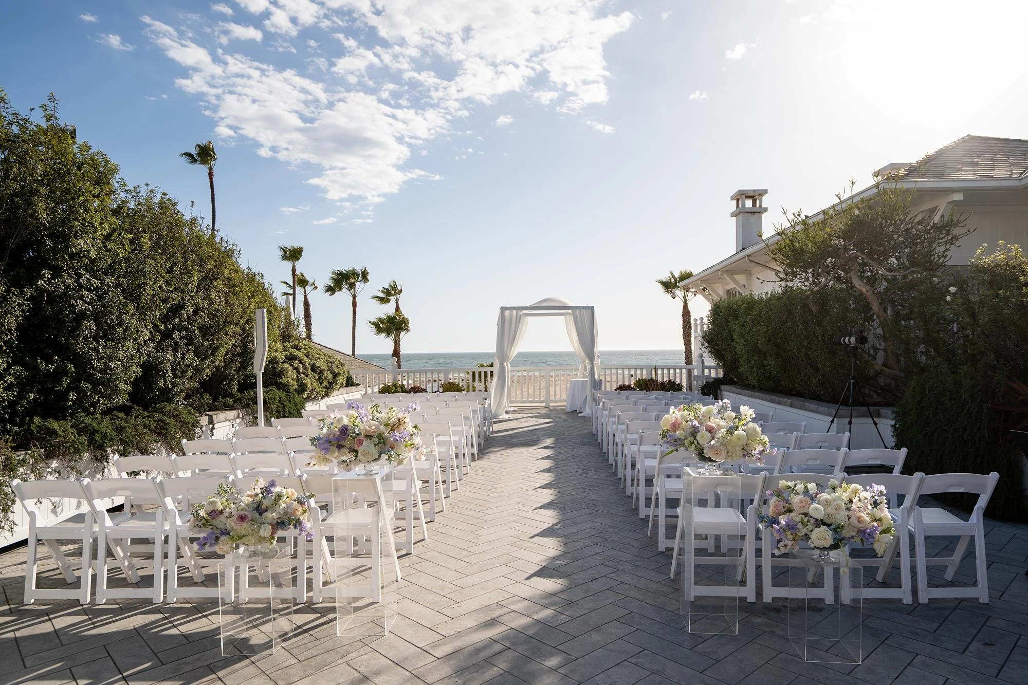 Wedding ceremony at Shutters on the Beach on Pacific Terrace featuring a chuppah draped in white fabric