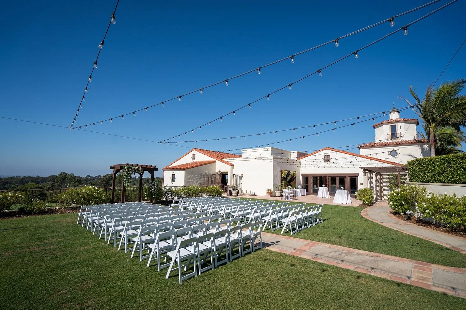 Wedding ceremony on the lawn with clubhouse backdrop at Palos Verdes Golf Club