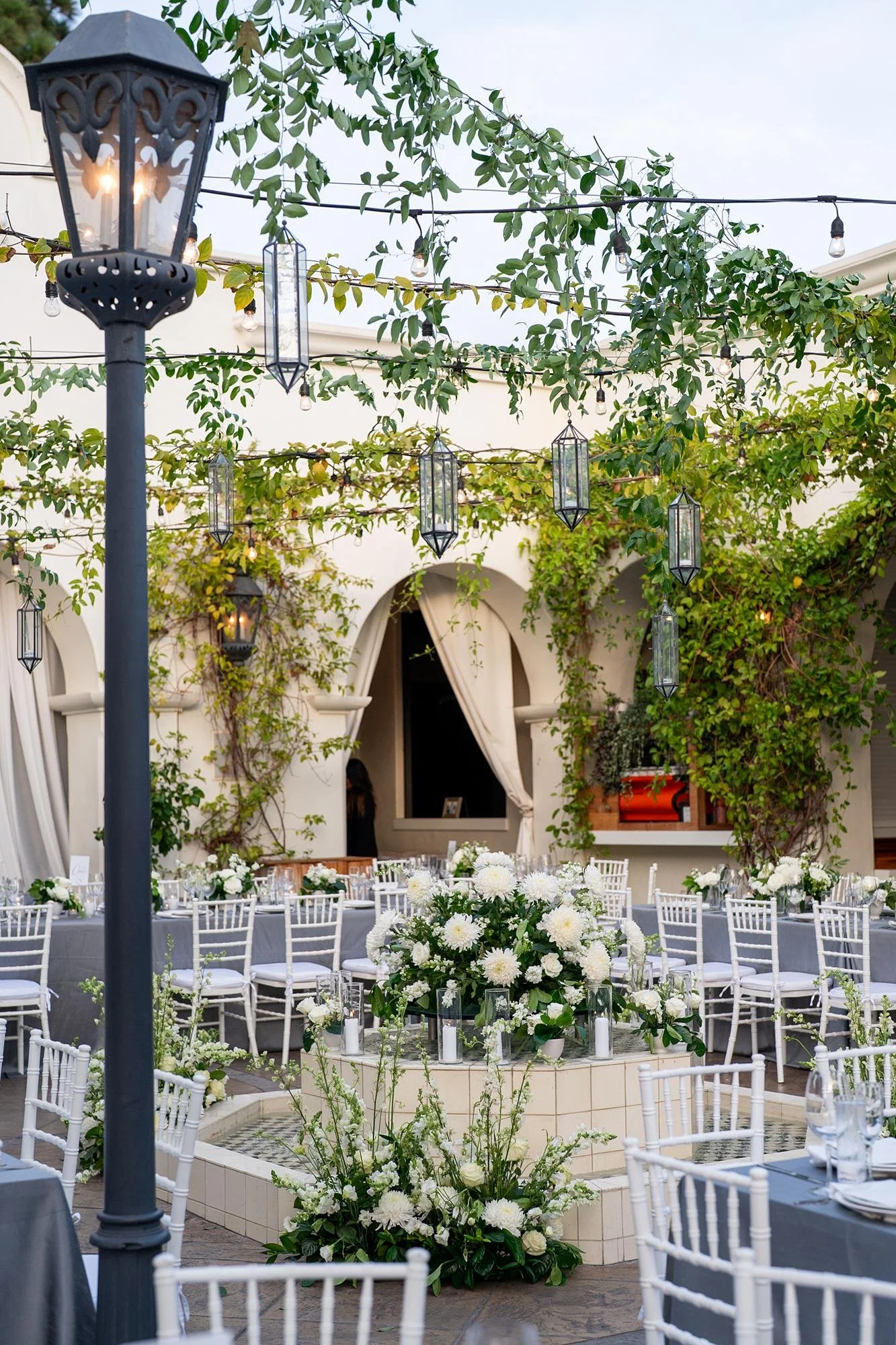 Wedding reception at Villa and Vine with fountain decorated in white florals and candles