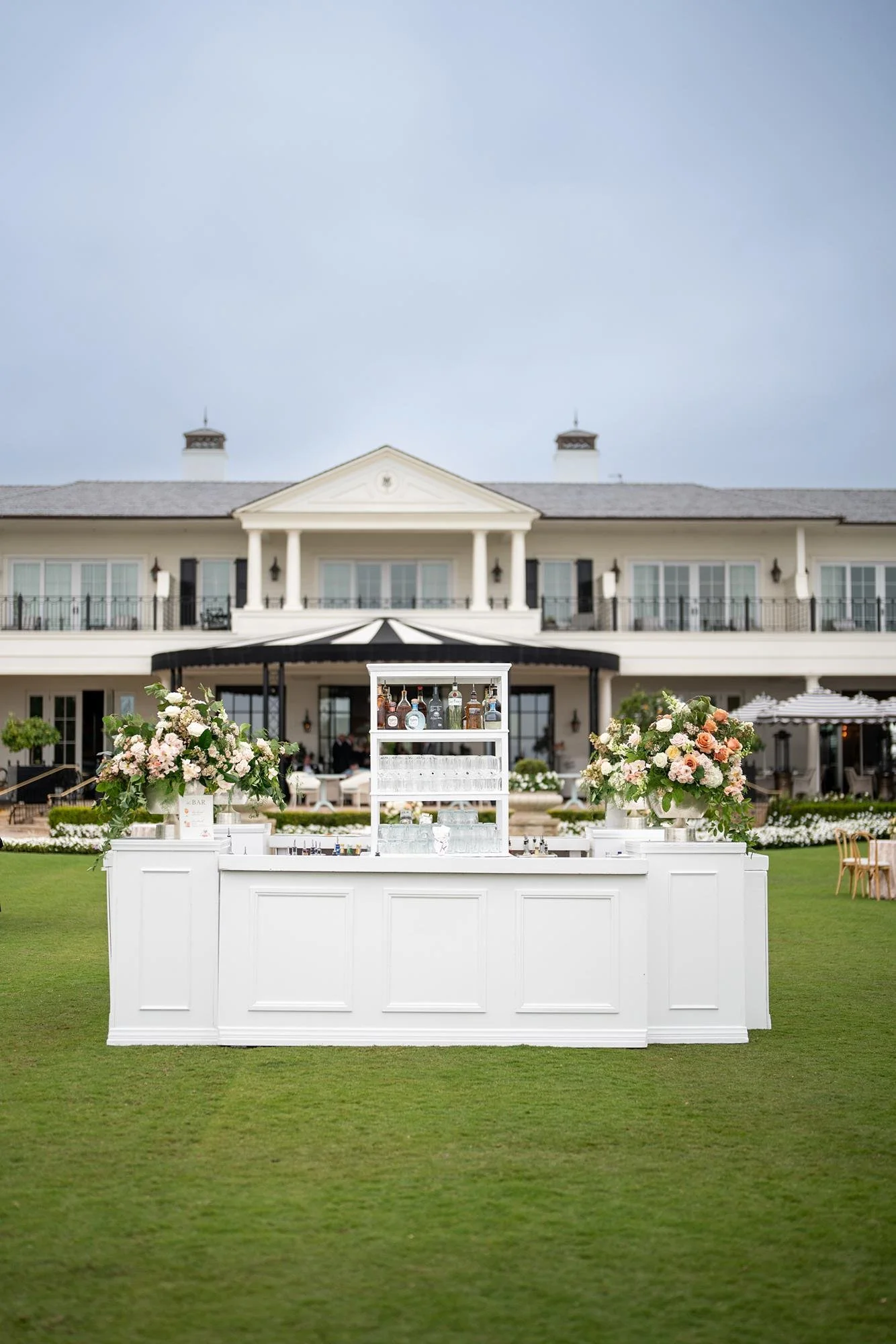 Custom wedding cocktail bar on the Great Lawn with a resort backdrop at Rosewood Miramar Beach