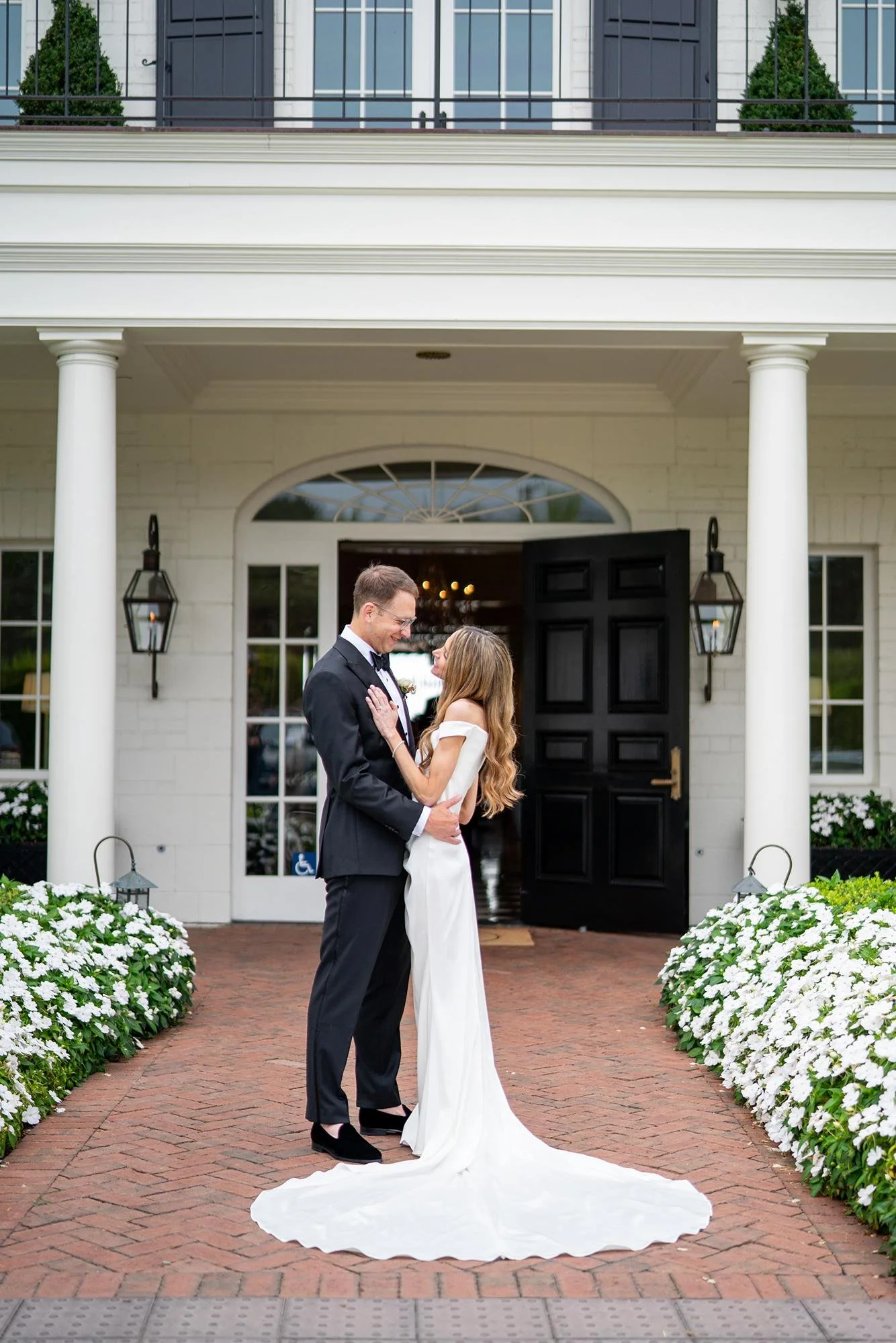 Bride and groom standing at the front entrance for wedding portraits at Rosewood Miramar Beach