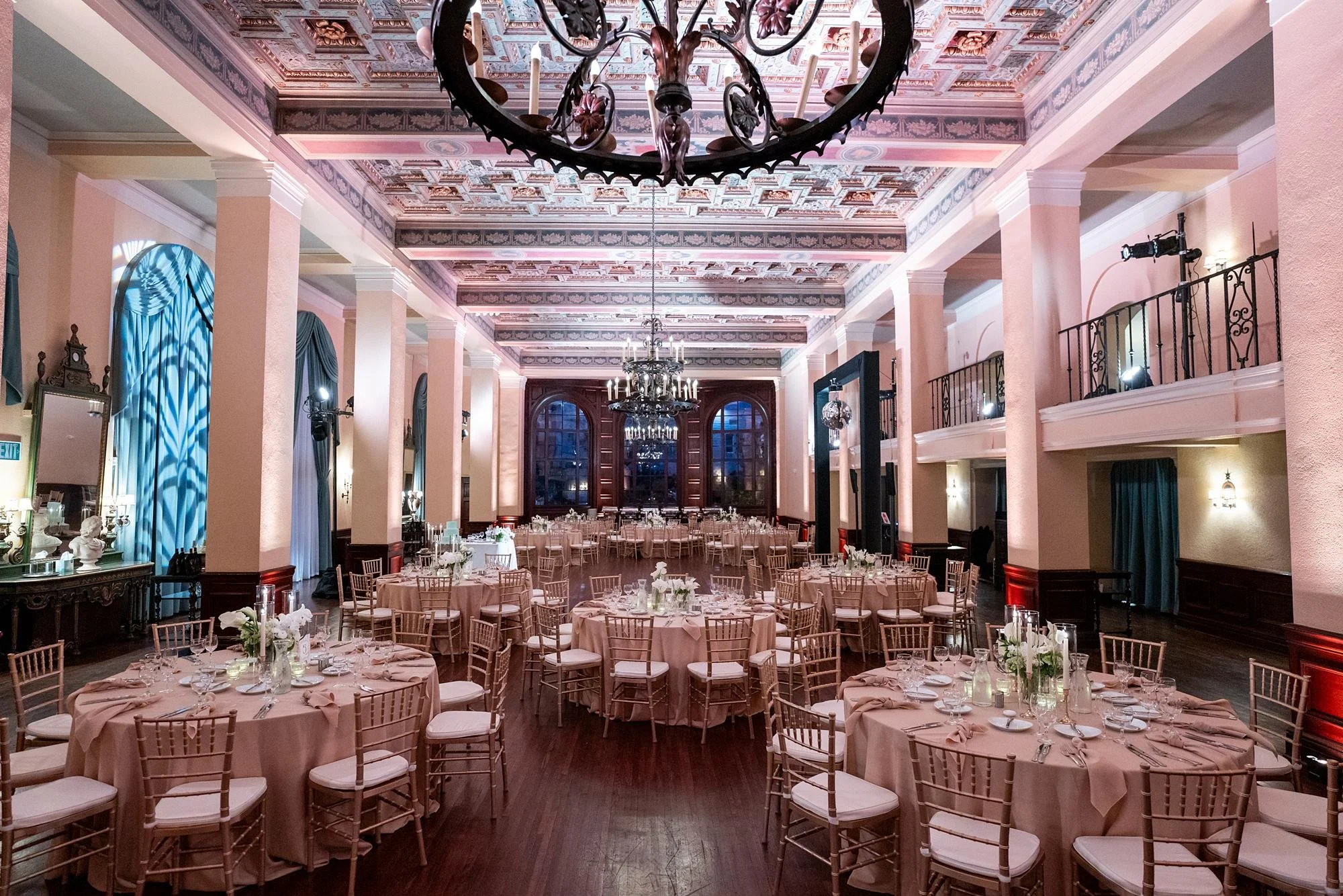 Wedding reception in the Lounge with circular and rectangle tables decorated with white florals and candles at Ebell of Los Angeles