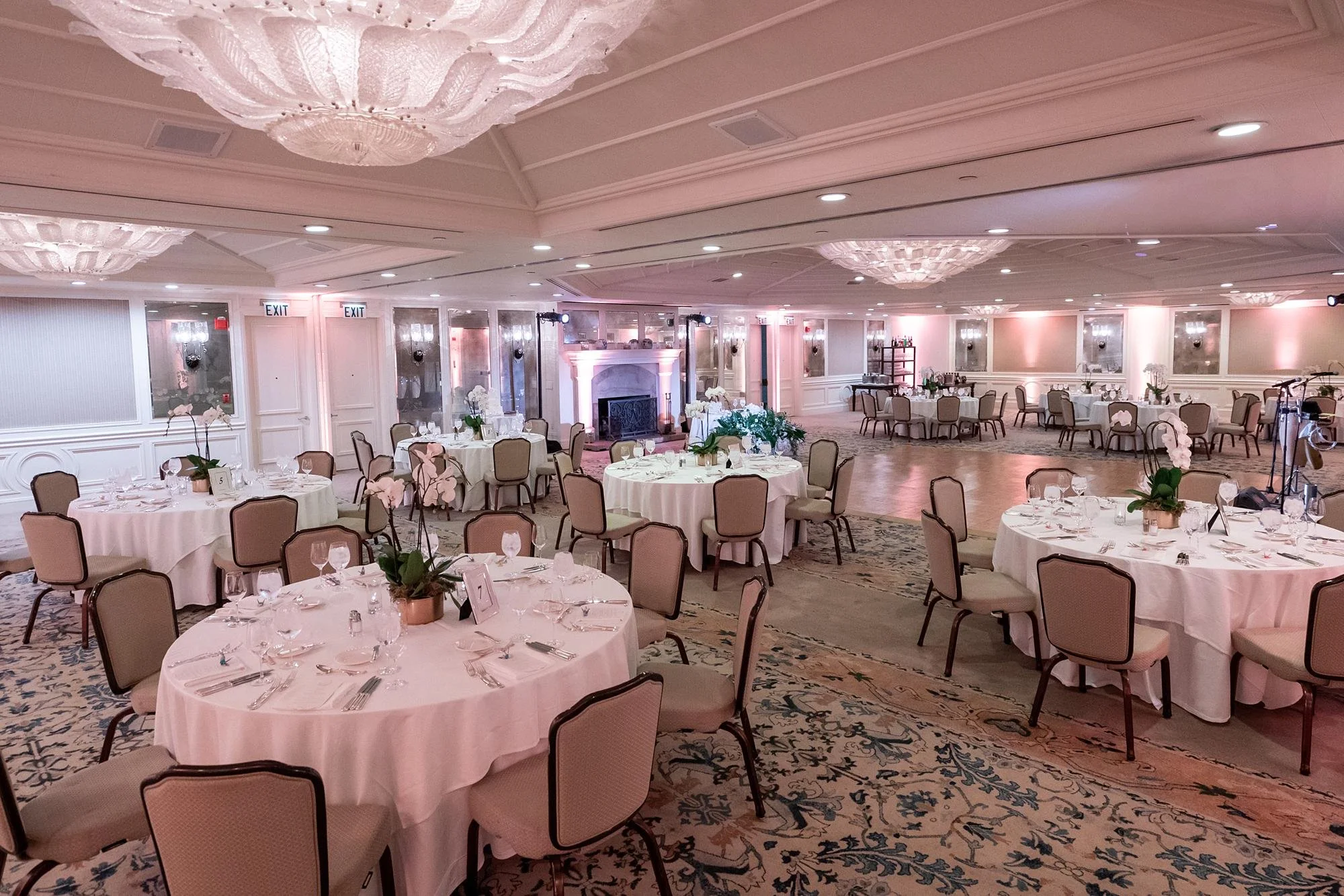 Wedding reception at Shutters on the Beach with pink lighting and orchid centerpieces in the Grand Salon