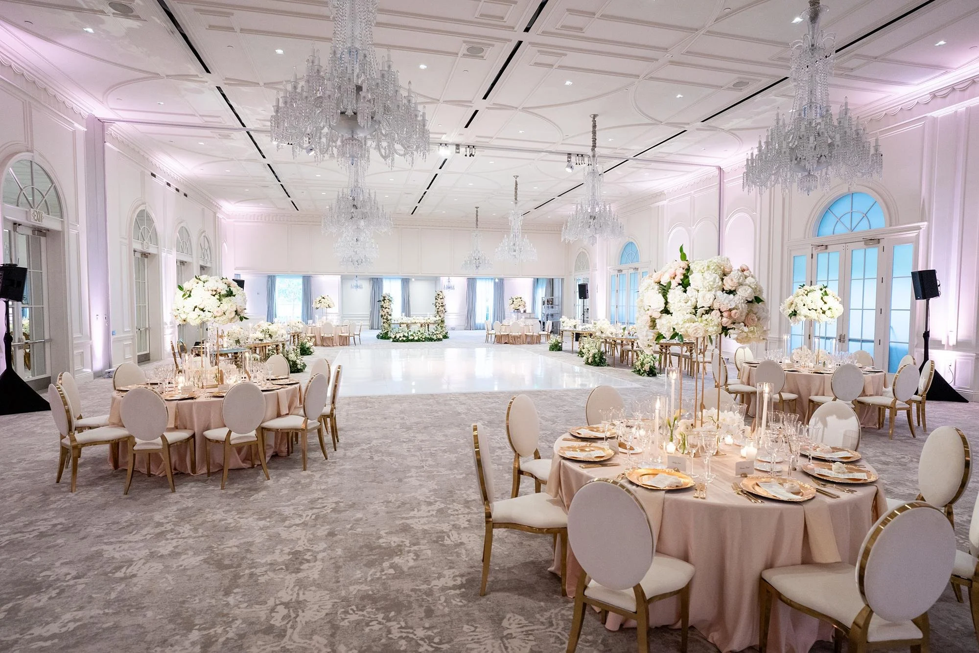 Wide view of a Chandelier Ballroom wedding reception with tables and décor at Rosewood Miramar Beach
