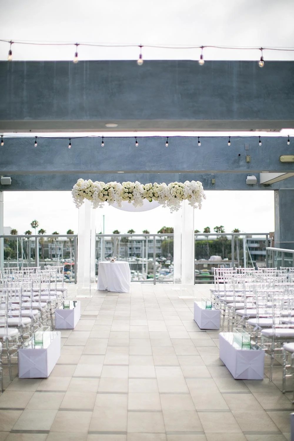 Wedding ceremony at Shade Hotel Redondo Beach on the Sky Level featuring a chuppah decorated with cascading roses