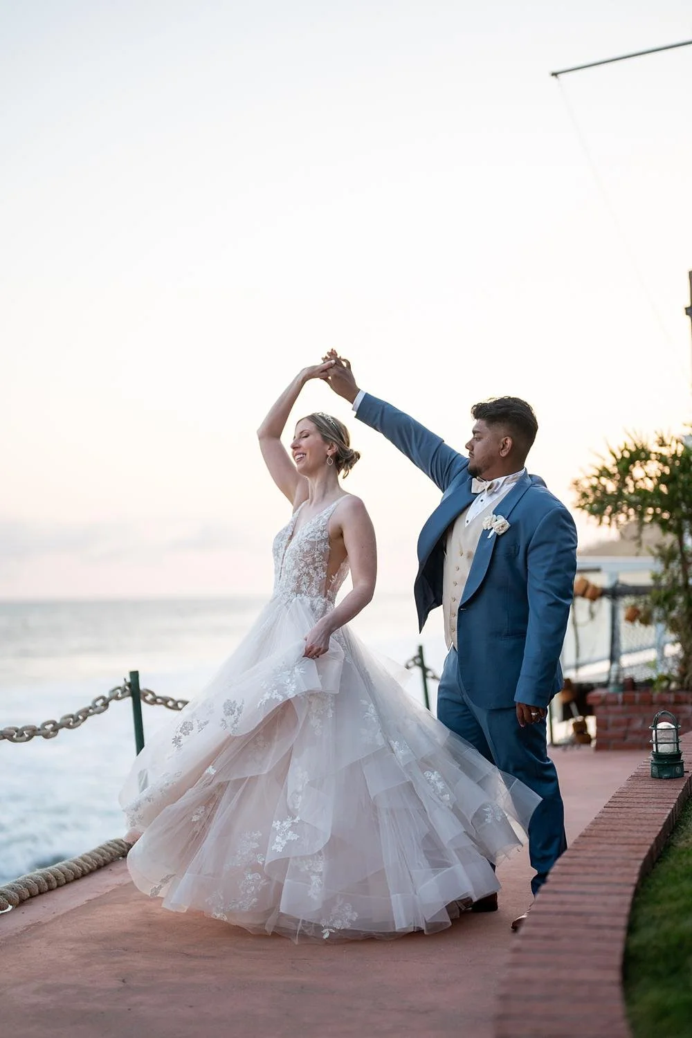 Wedding portraits of bride twirling on an oceanfront path at Cypress Sea Cove