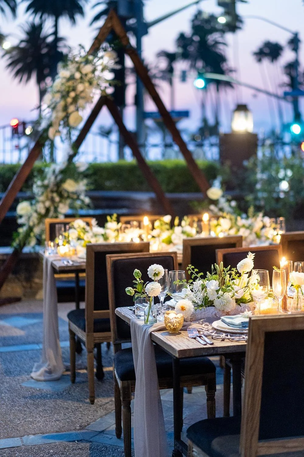Detail of tables draped with fabric, florals, and candles during Sunset Terrace wedding reception