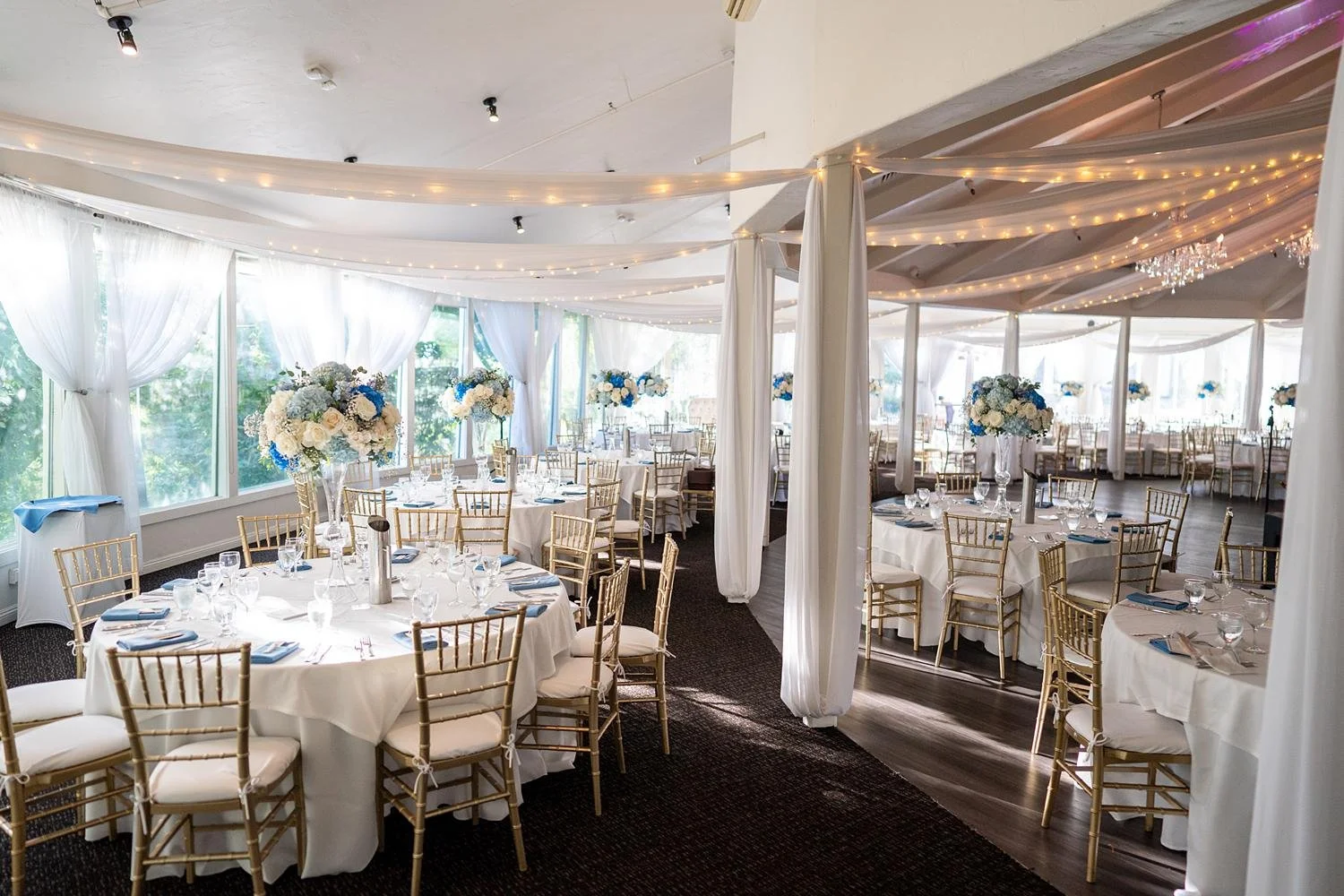 Wedding reception wide shot featuring tall blue and white floral centerpieces at  The Vineyards Simi Valley