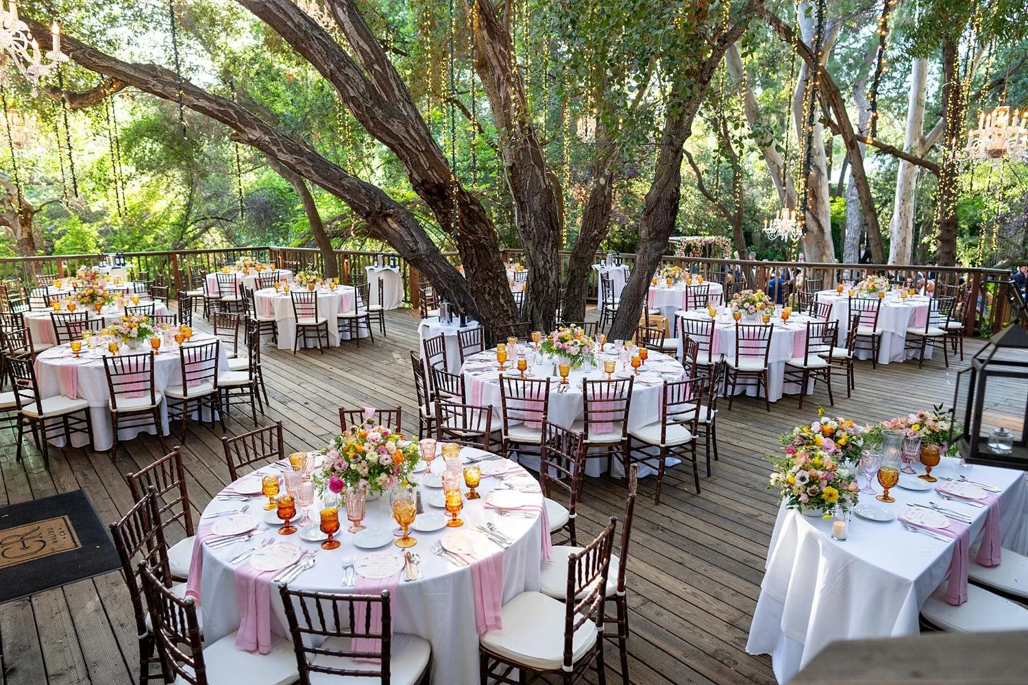 Wedding reception at Calamigos Ranch Birchwood patio with guests dining beneath hanging lights