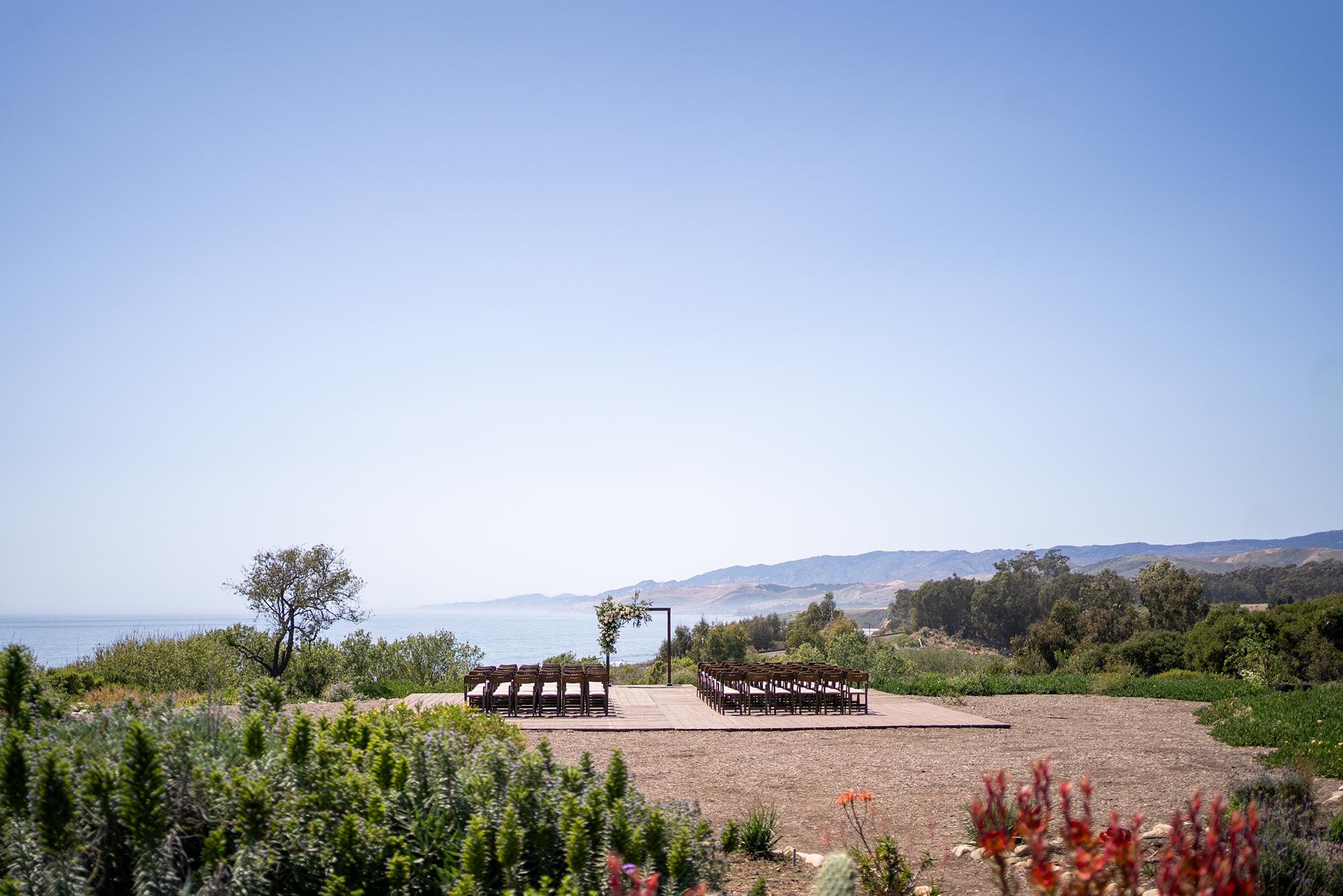 Wedding ceremony featuring floral-covered angular arch and coastal views at Dos Pueblos Orchid Farm