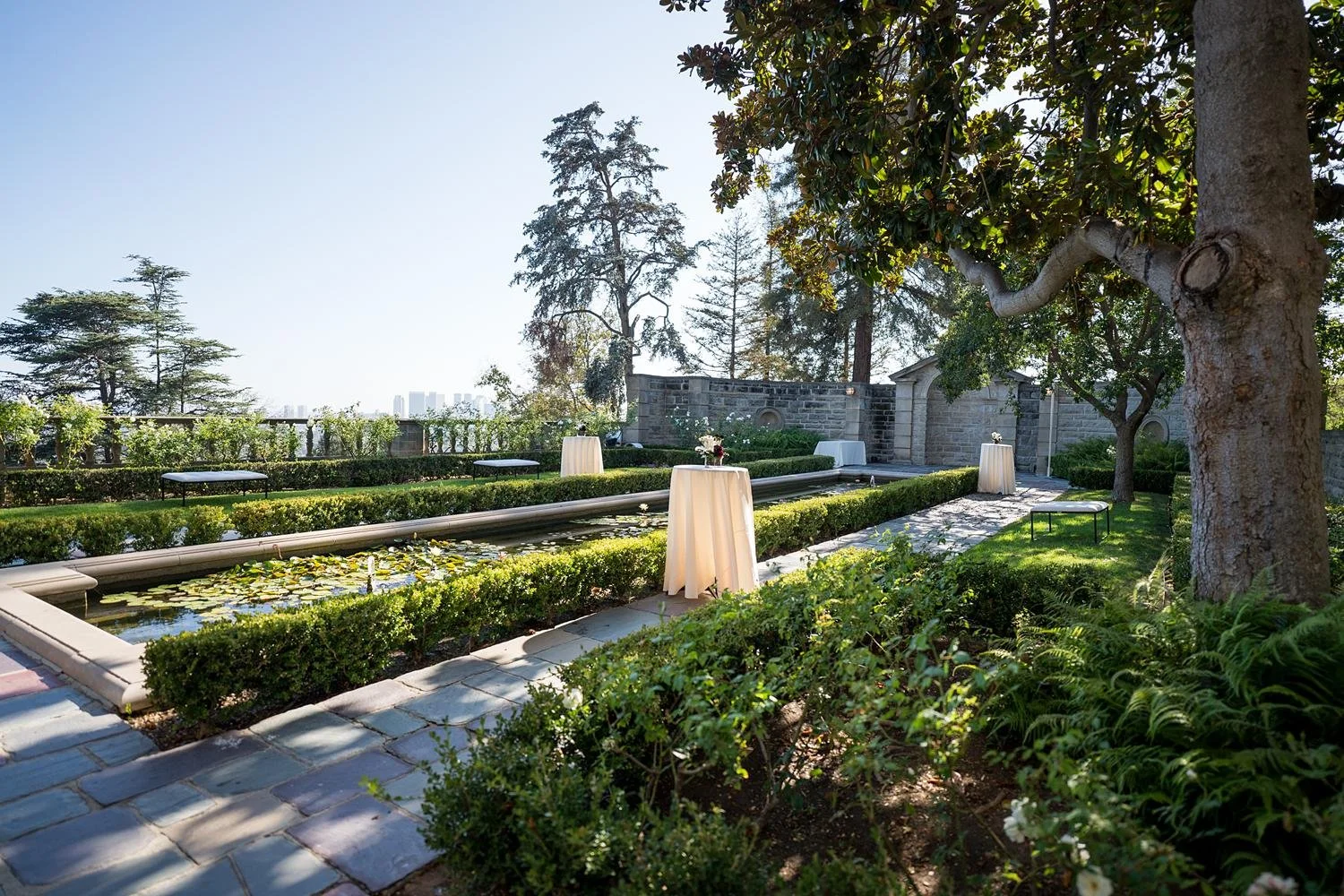 Wedding cocktails setup with high-top tables arranged around the Reflection Pond at Greystone Mansion
