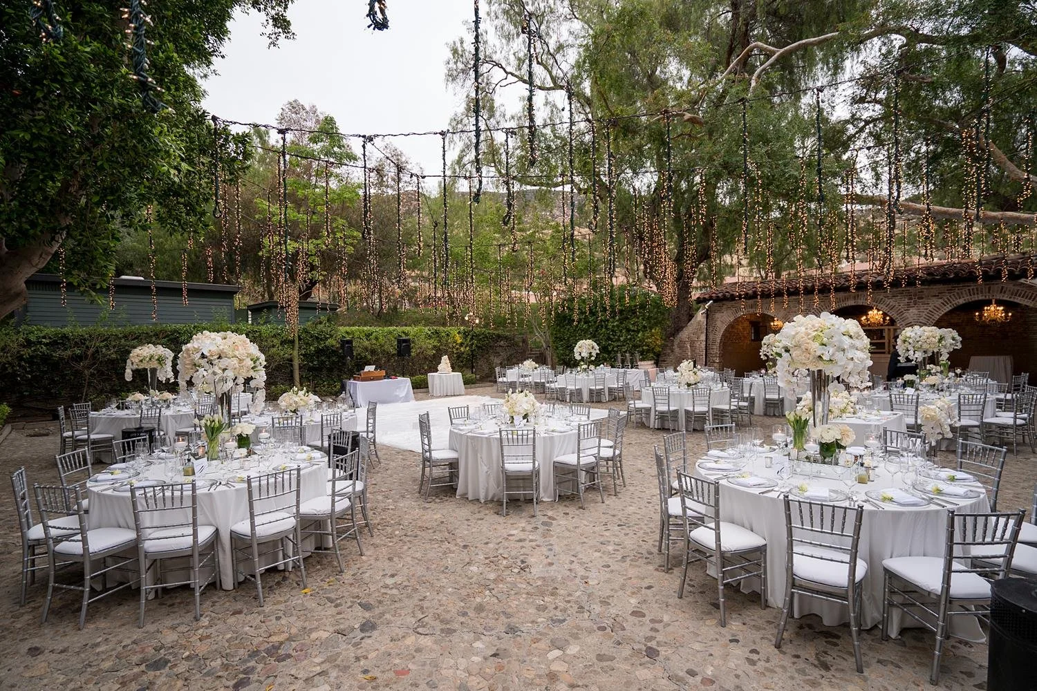 Elegant white florals and fairy lights during a Sitting Bull wedding reception at Hummingbird Nest Ranch