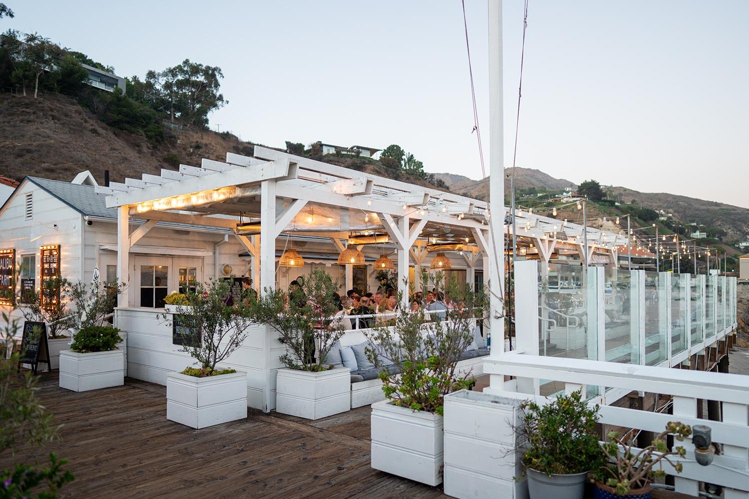 Wedding reception at Malibu Farm at the Pier during sunset with hanging lights