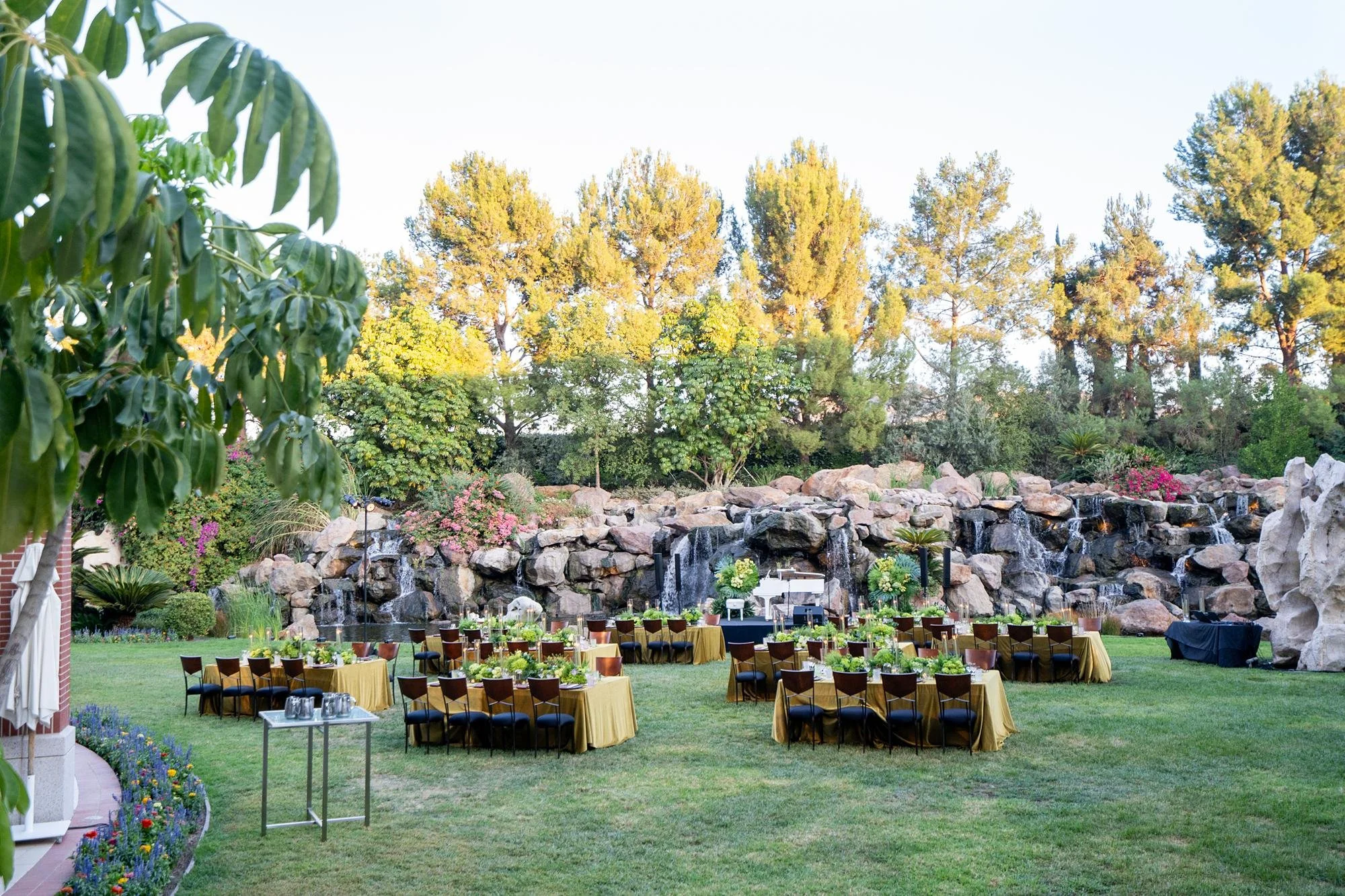 Wedding reception at Four Seasons Westlake with candlelit tables arranged across the Waterfall Lawn