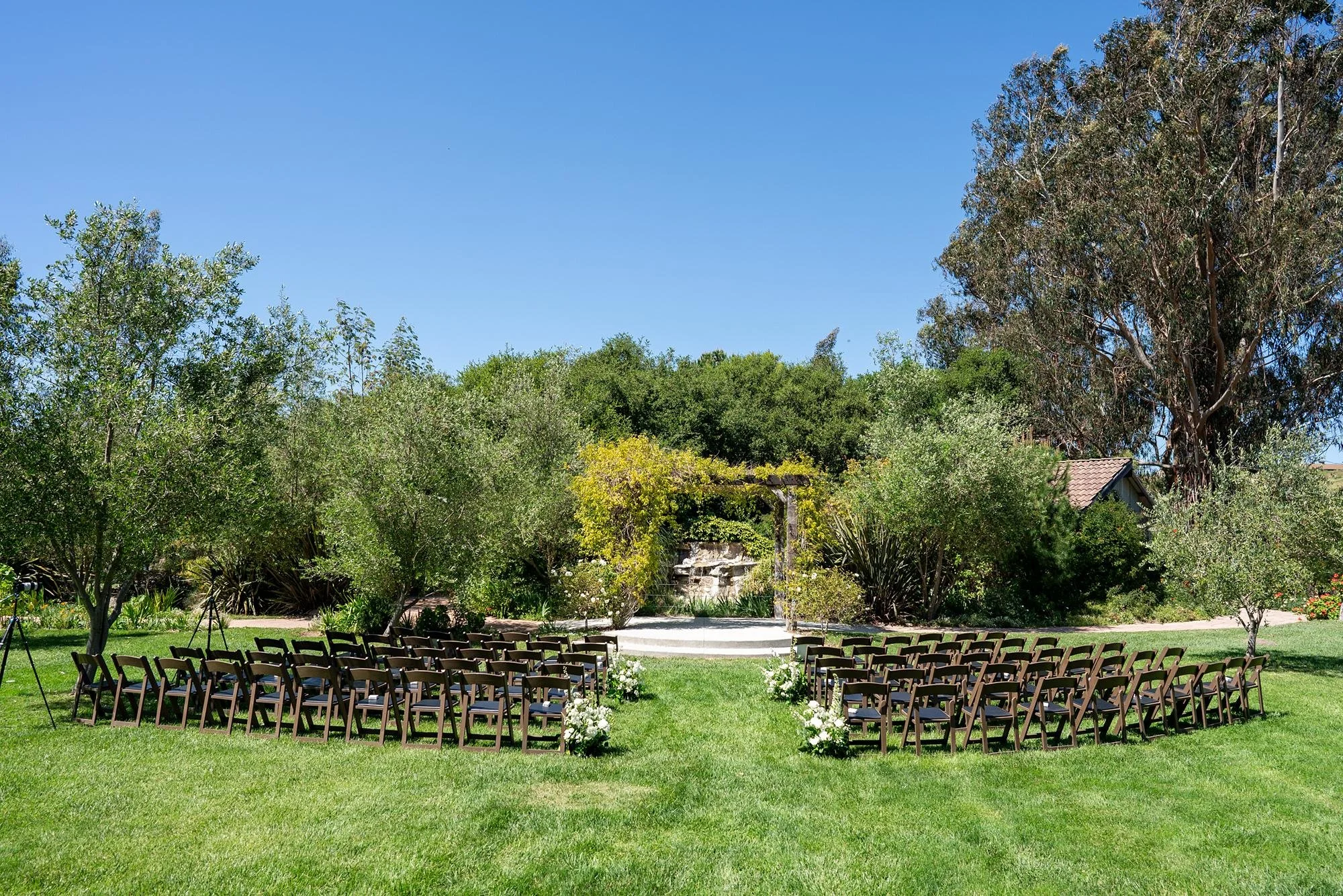 Wedding ceremony aisle lined with white roses during an outdoor ceremony at La Arboleda