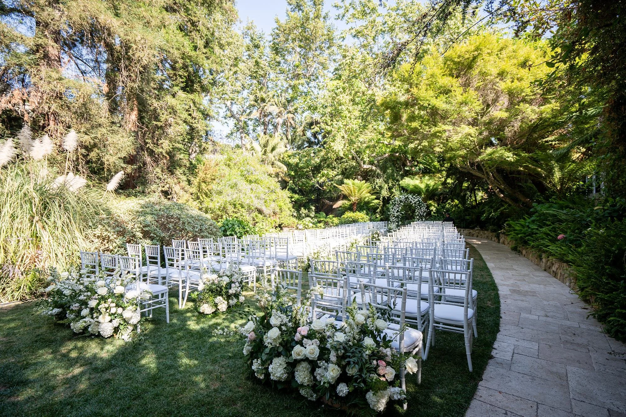 Wedding ceremony at Hotel Bel Air with white floral arch overlooking Swan Lake