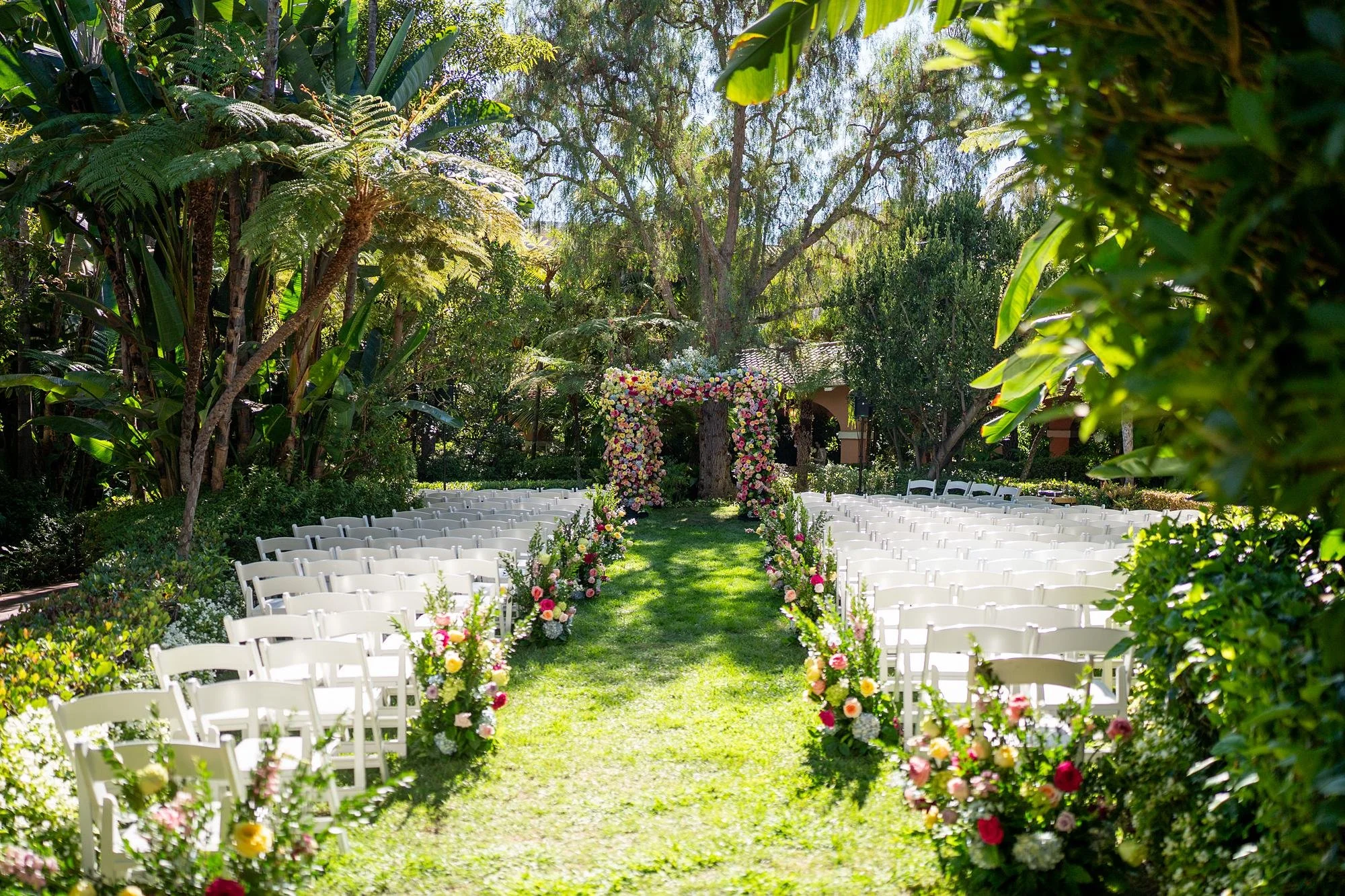 Wedding ceremony in the Polo Garden at the Beverly Hills Hotel with vibrant floral arrangements