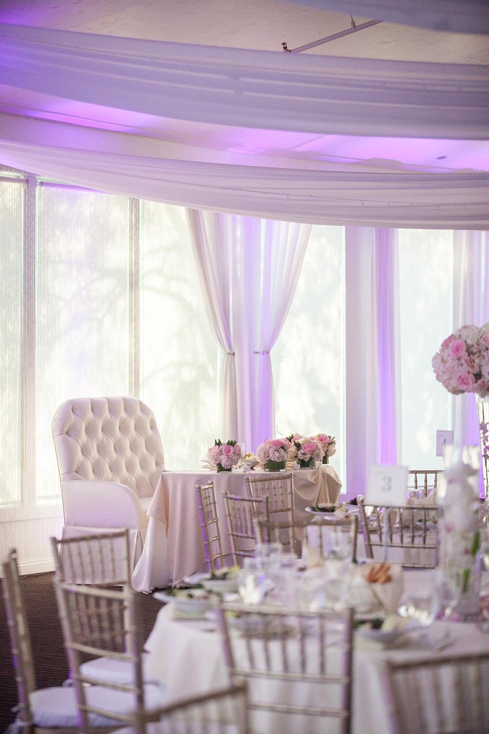 Wedding reception detail of the sweetheart table positioned against windows at The Vineyards Simi Valley