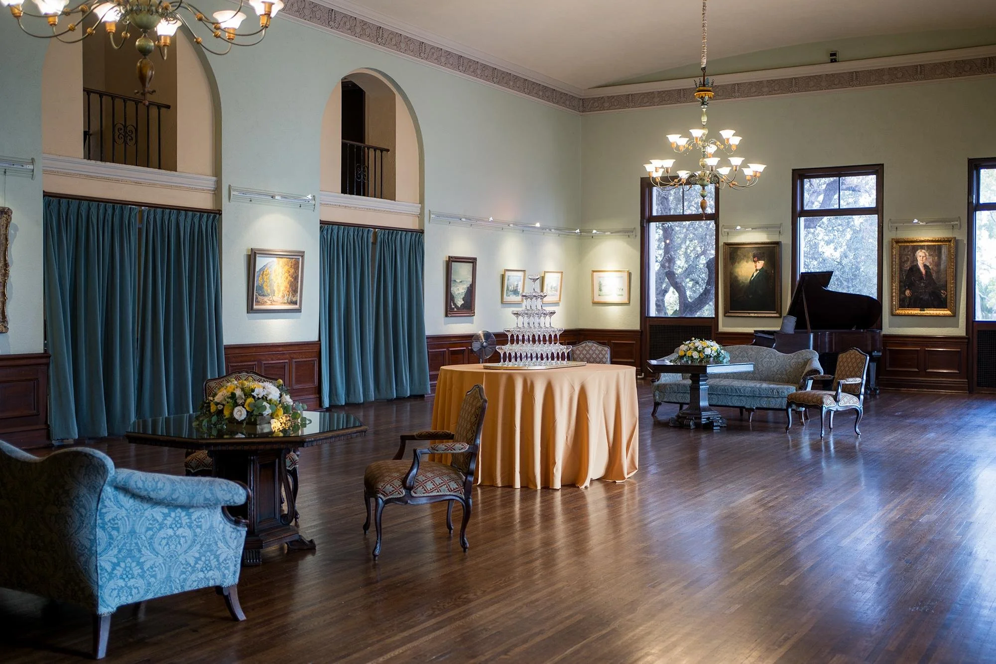 Wedding cocktails in Art Salon featuring champagne tower, grand piano, and vintage couches at Ebell of Los Angeles 9.