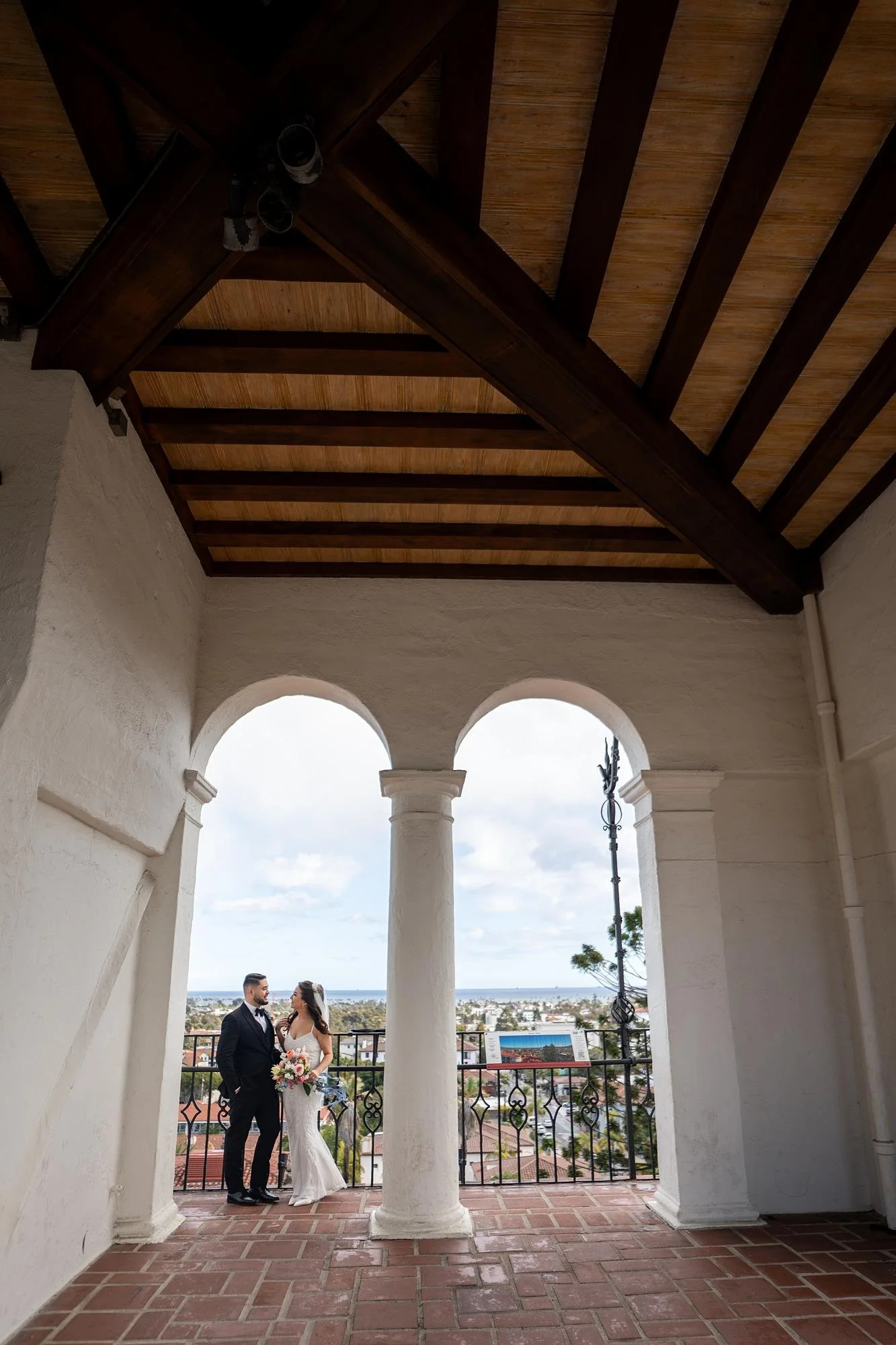 Wedding portrait of a couple overlooking Santa Barbara from the clock tower at the Santa Barbara Courthouse