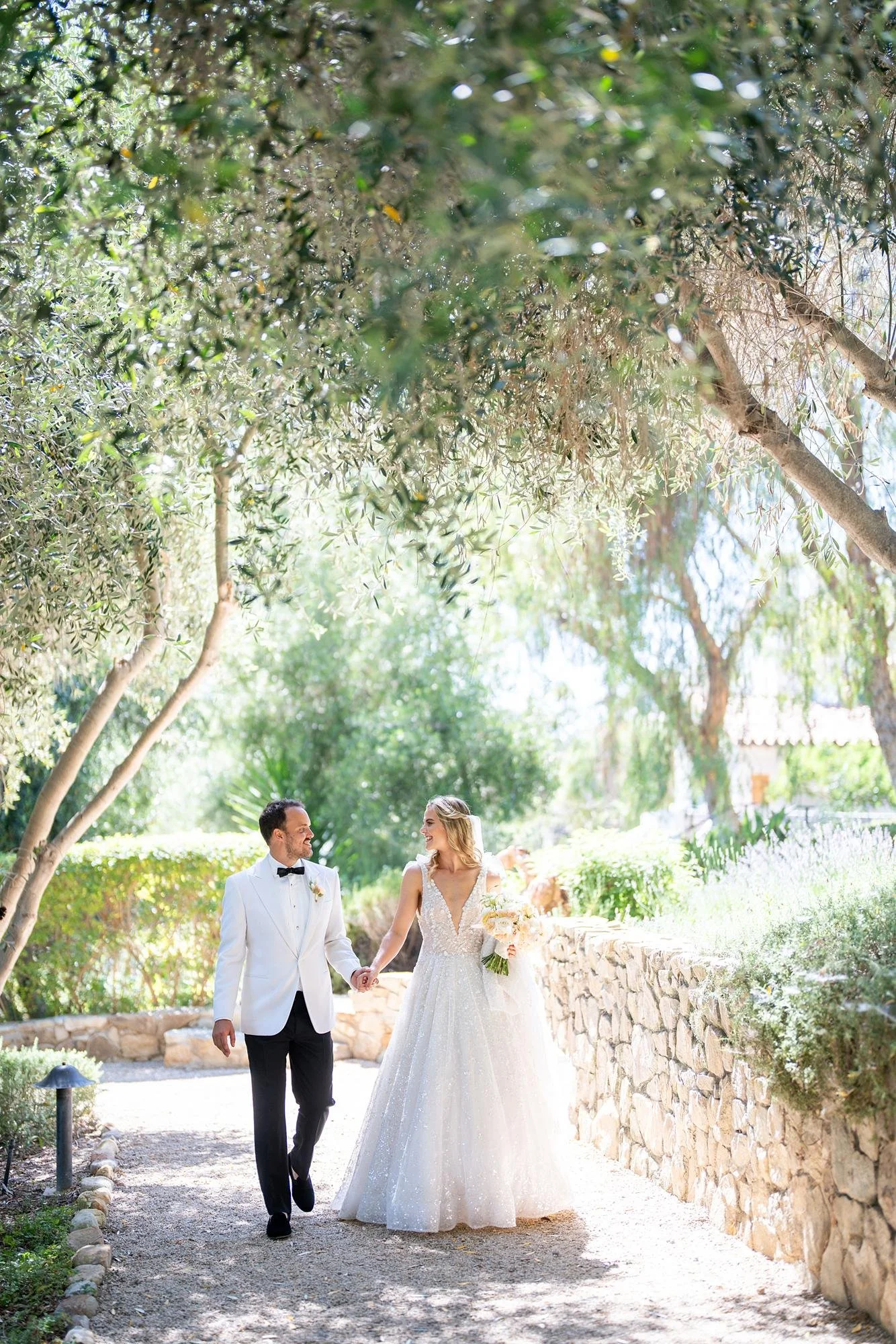 Wedding portrait of bride and groom walking through the Herb Garden at Ojai Valley Inn and Spa