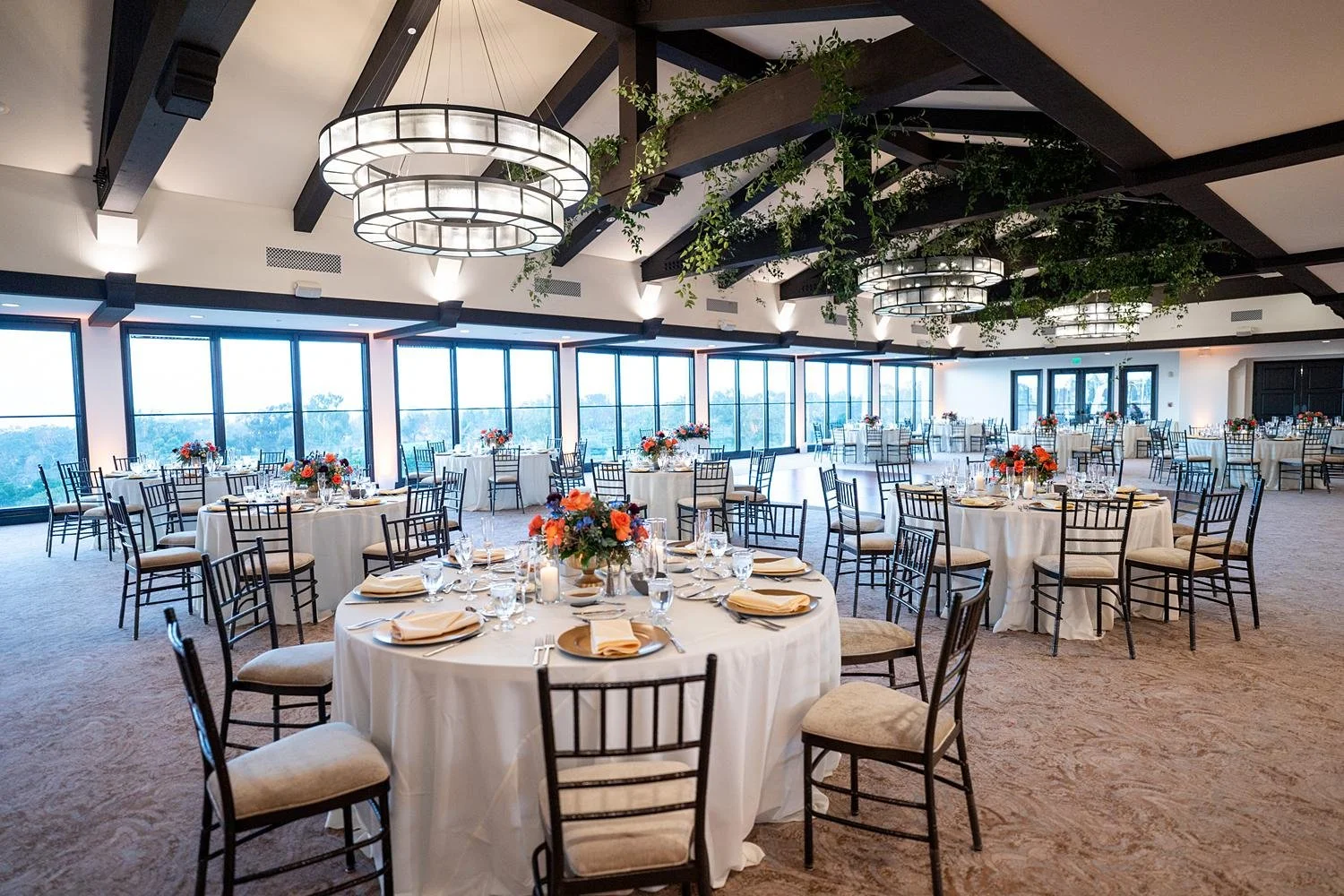 Wedding reception inside the clubhouse at Palos Verdes Golf Club with vines hanging from wooden beams
