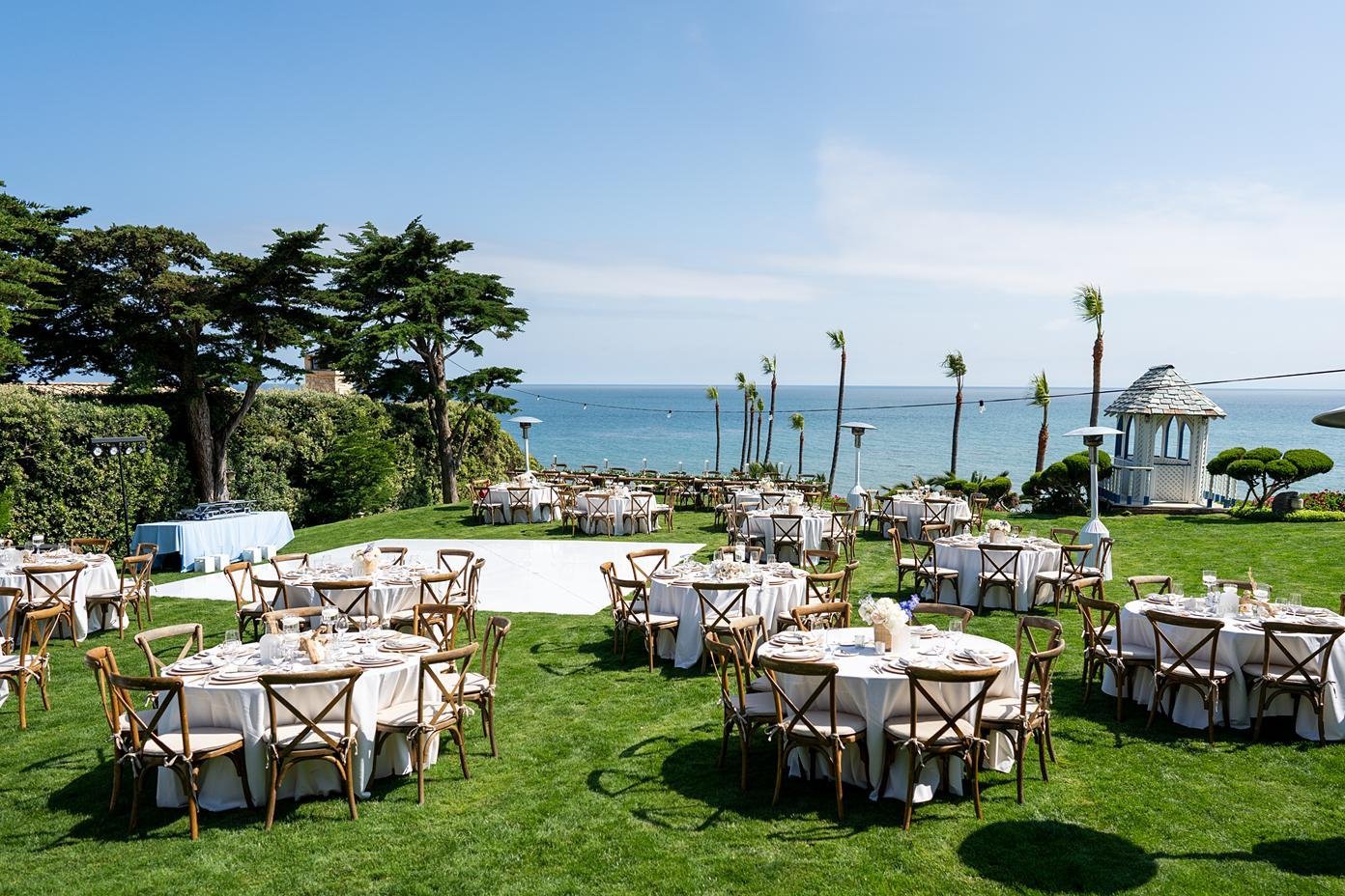 Wedding reception wide view of decor with ocean backdrop at Cypress Sea Cove