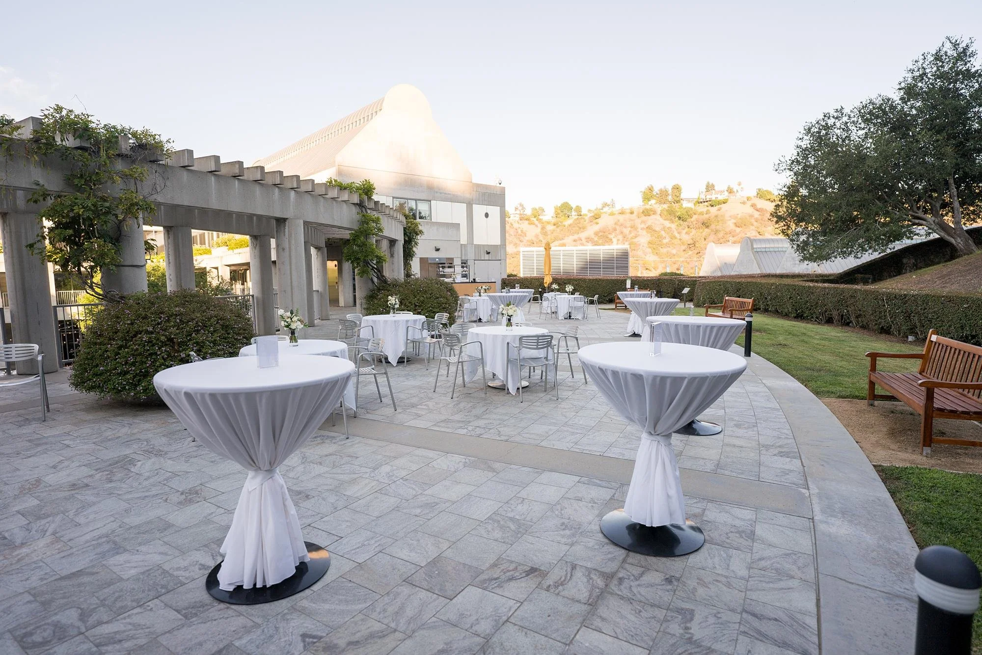 Cocktail tables and décor arranged for a wedding cocktail hour on the Garden Terrace at the Skirball Cultural Center