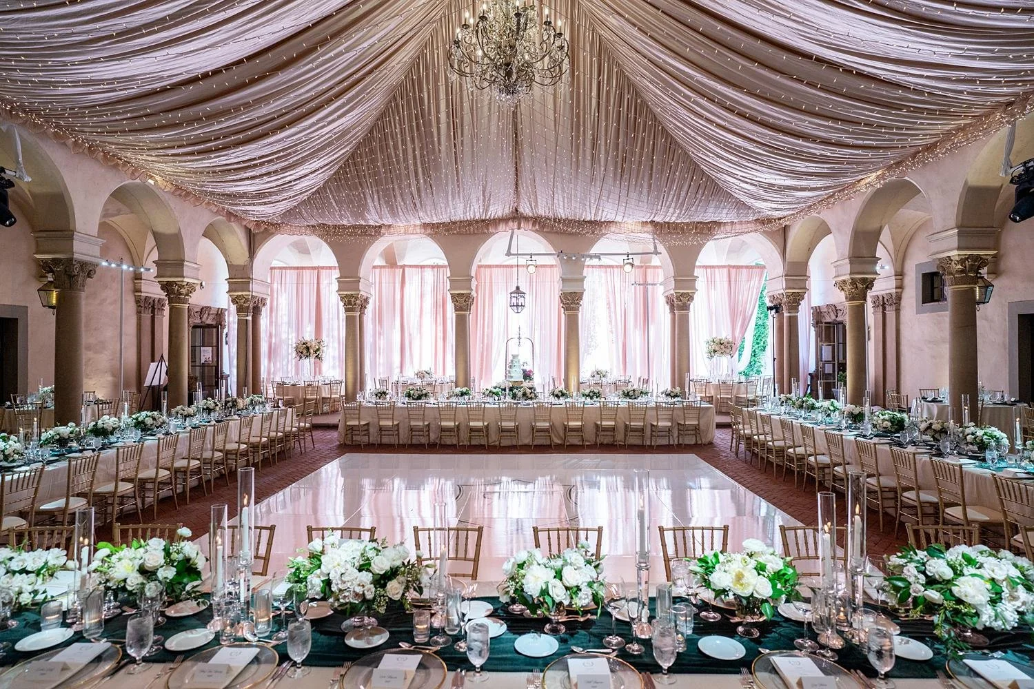 Wedding reception in the Inner Courtyard with long tables surrounding a monogrammed dance floor at the Athenaeum at Caltech