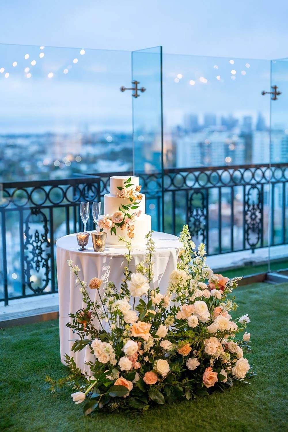 Wedding reception on the West End Rooftop at the London West Hollywood featuring a rose-adorned cake table with city views