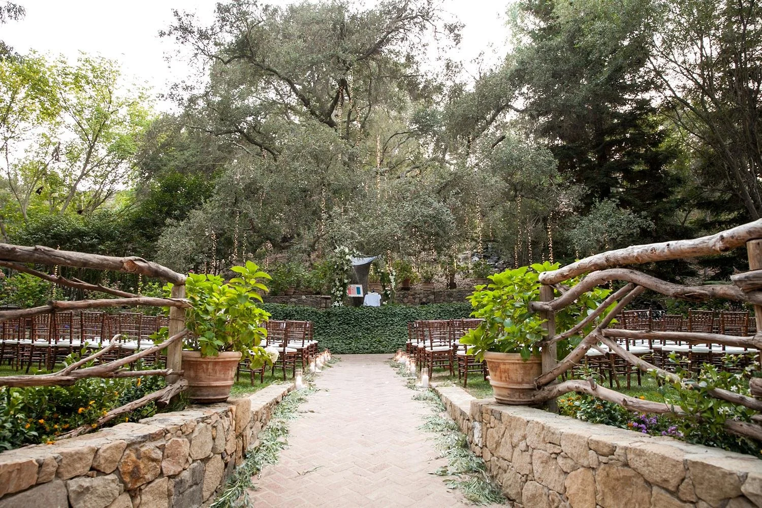 Wedding ceremony at Calamigos Ranch Pavilion set beneath trees with hanging lights