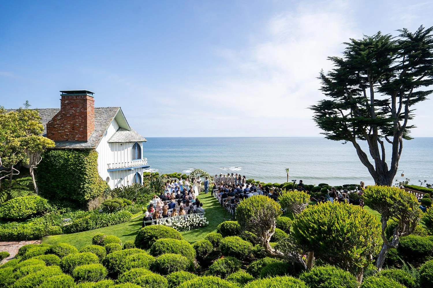 Wedding ceremony with guests watching vows overlooking the ocean at Cypress Sea Cove