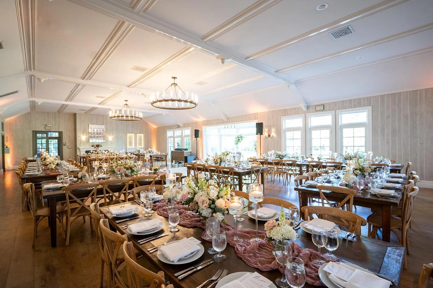 Wedding reception in the Ballroom at the Lodge at Malibou Lake with pink fabric runners and rose centerpieces
