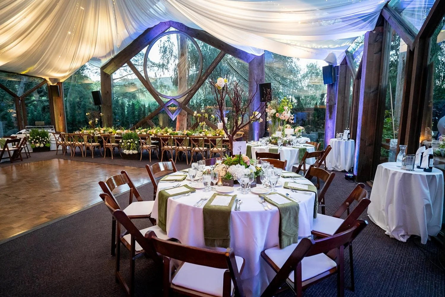 Wedding reception at Calamigos Ranch Oak Room with draped fabric and greenery-inspired decor