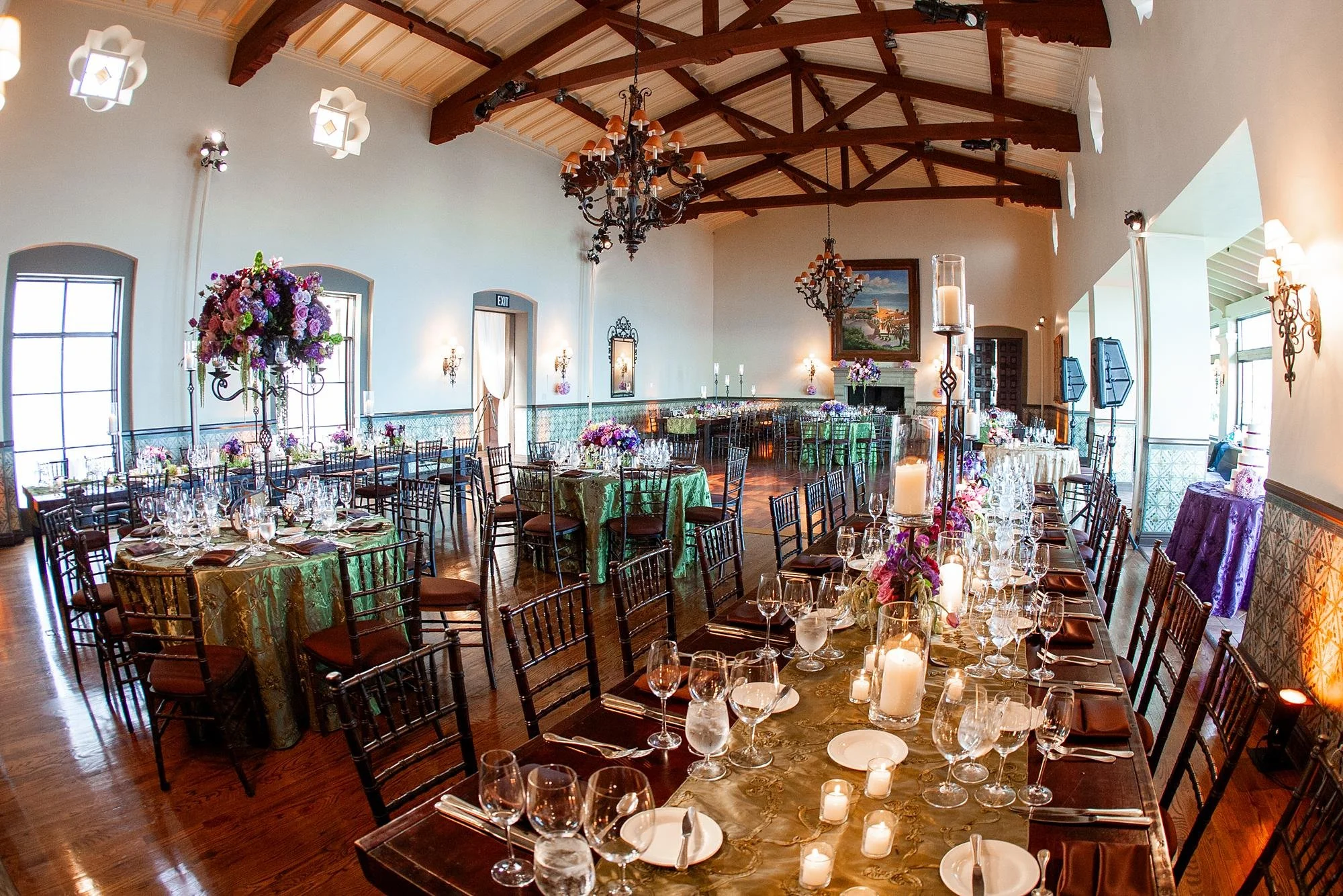 Wide view of living room wedding reception with tables and décor at Bel Air Bay Club