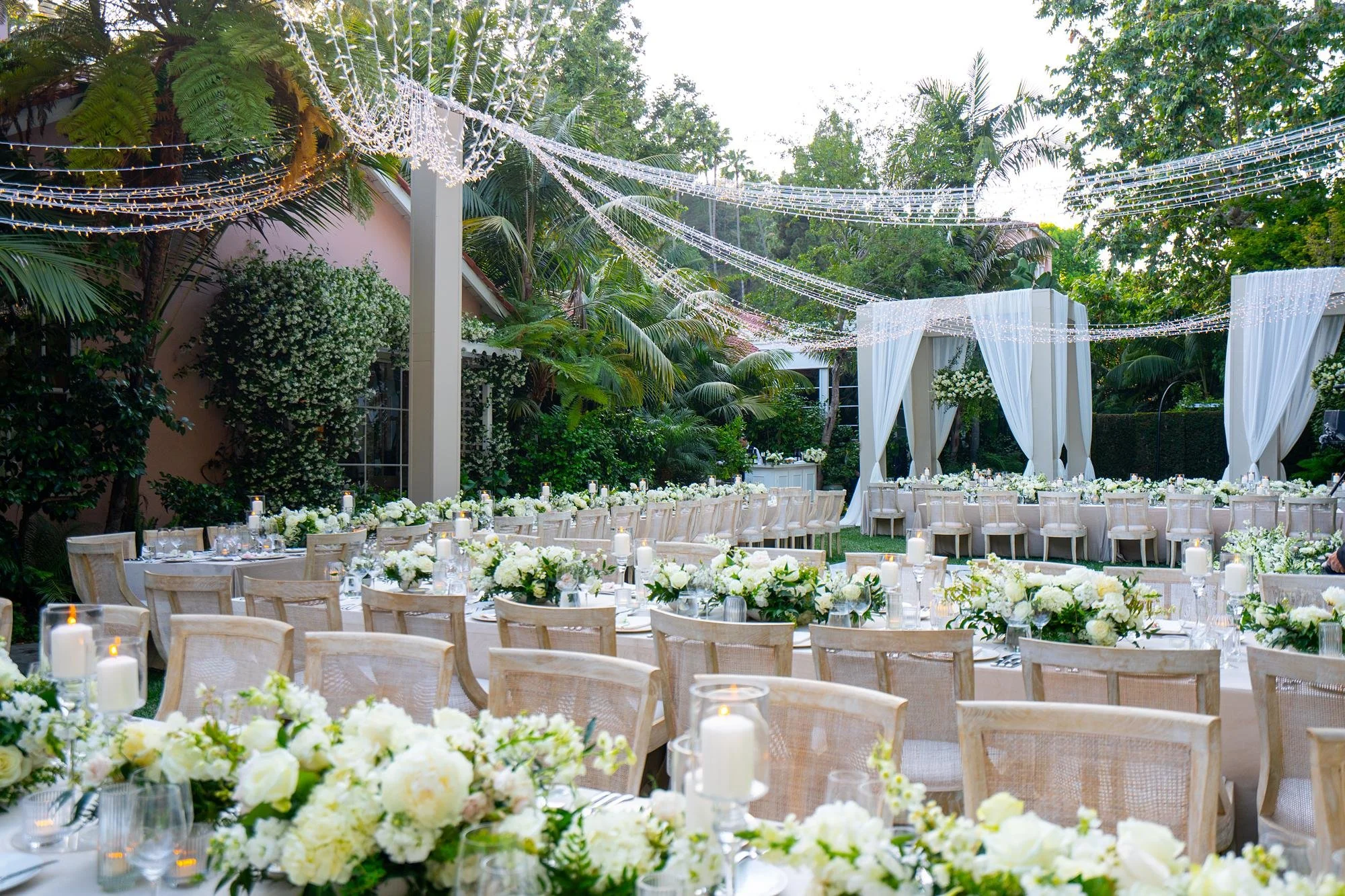 Wedding reception on the lawn at Hotel Bel Air with floral chandeliers, centerpieces, and string lights