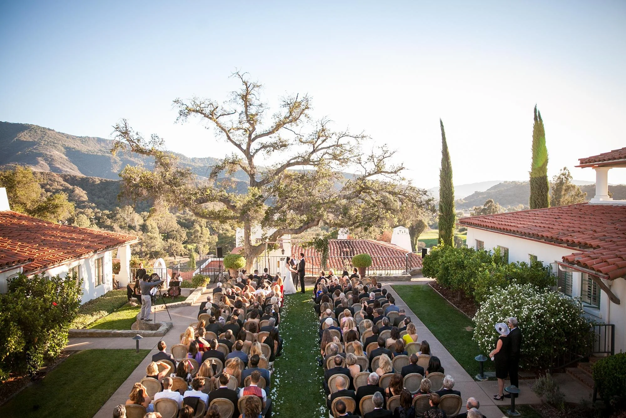 Overhead view of wedding ceremony as couple exchange vows in the Hacienda Courtyard at Ojai Valley Inn and Spa