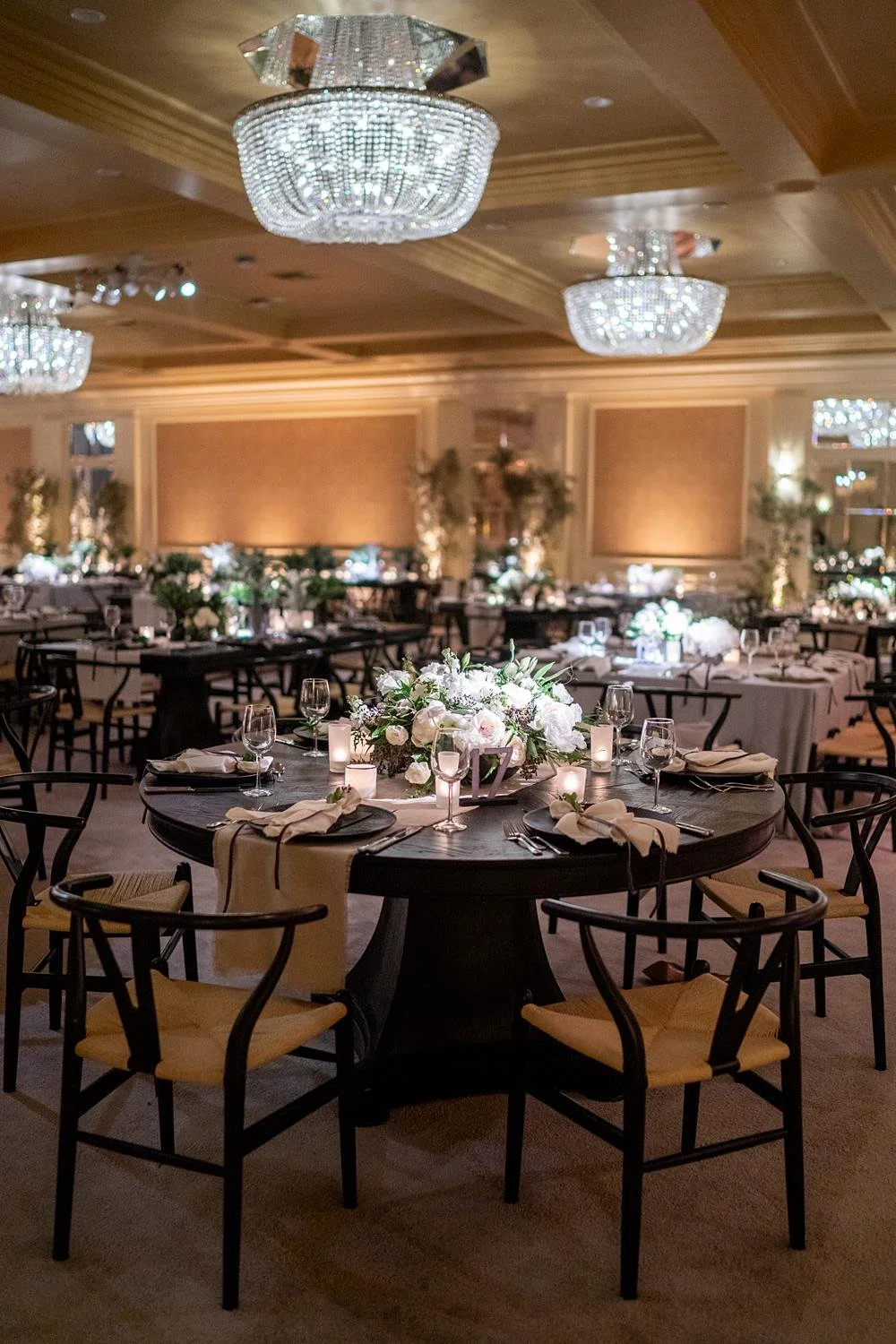 Detailed view of modern circular wood table with white florals at Wedgwood Ballroom wedding reception